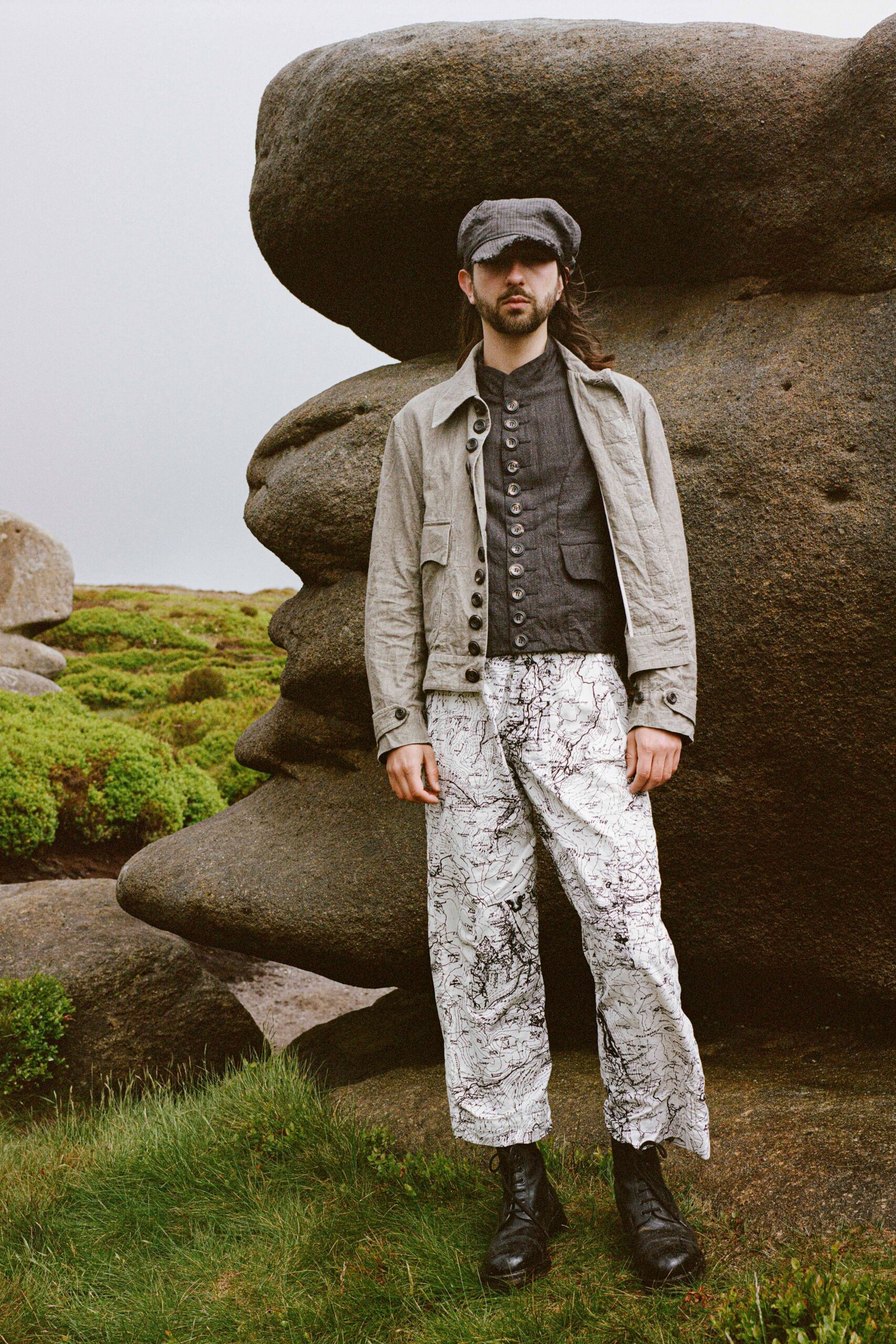 beige jacket black shirt white printed pants