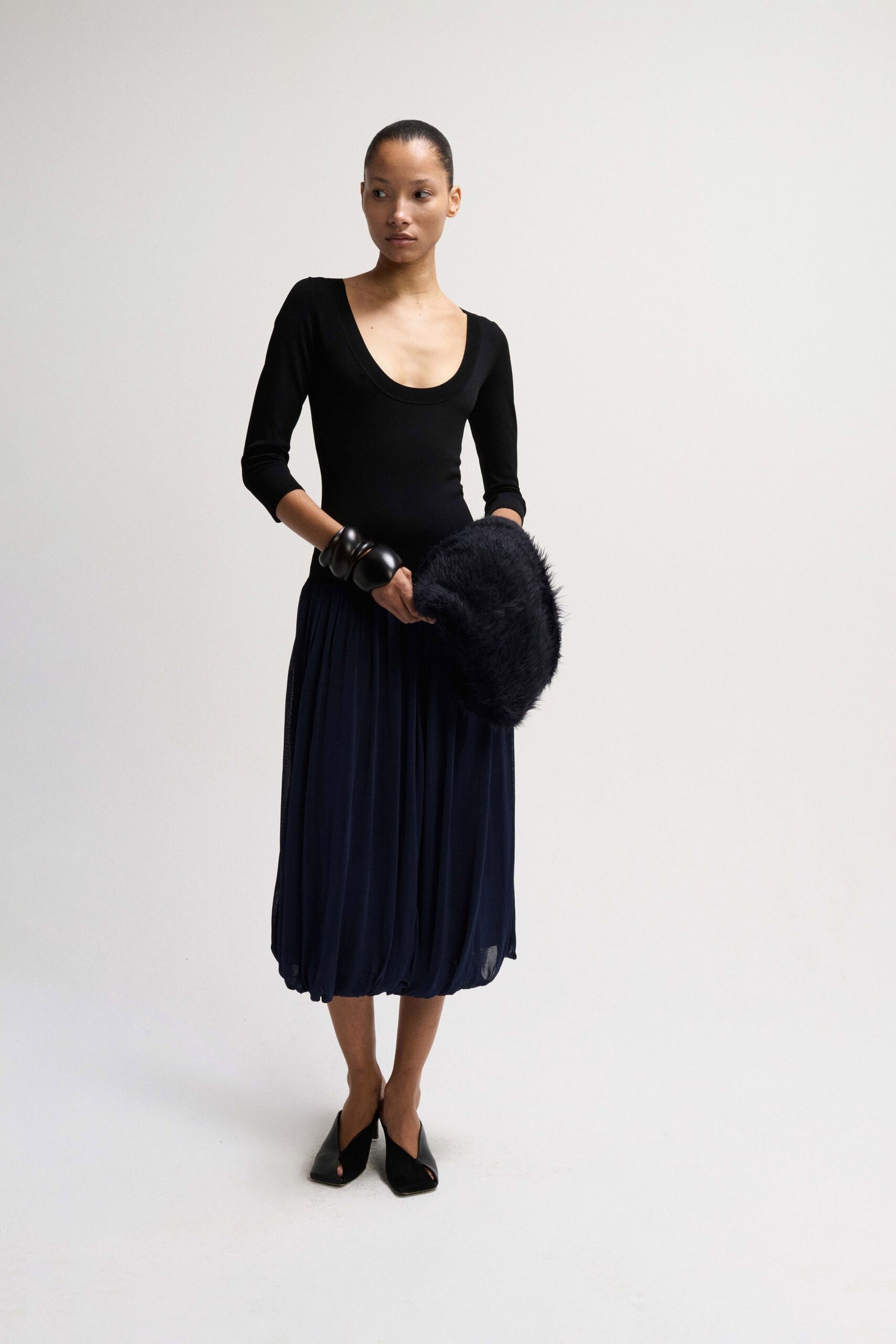 black bodysuit blue pleated skirt