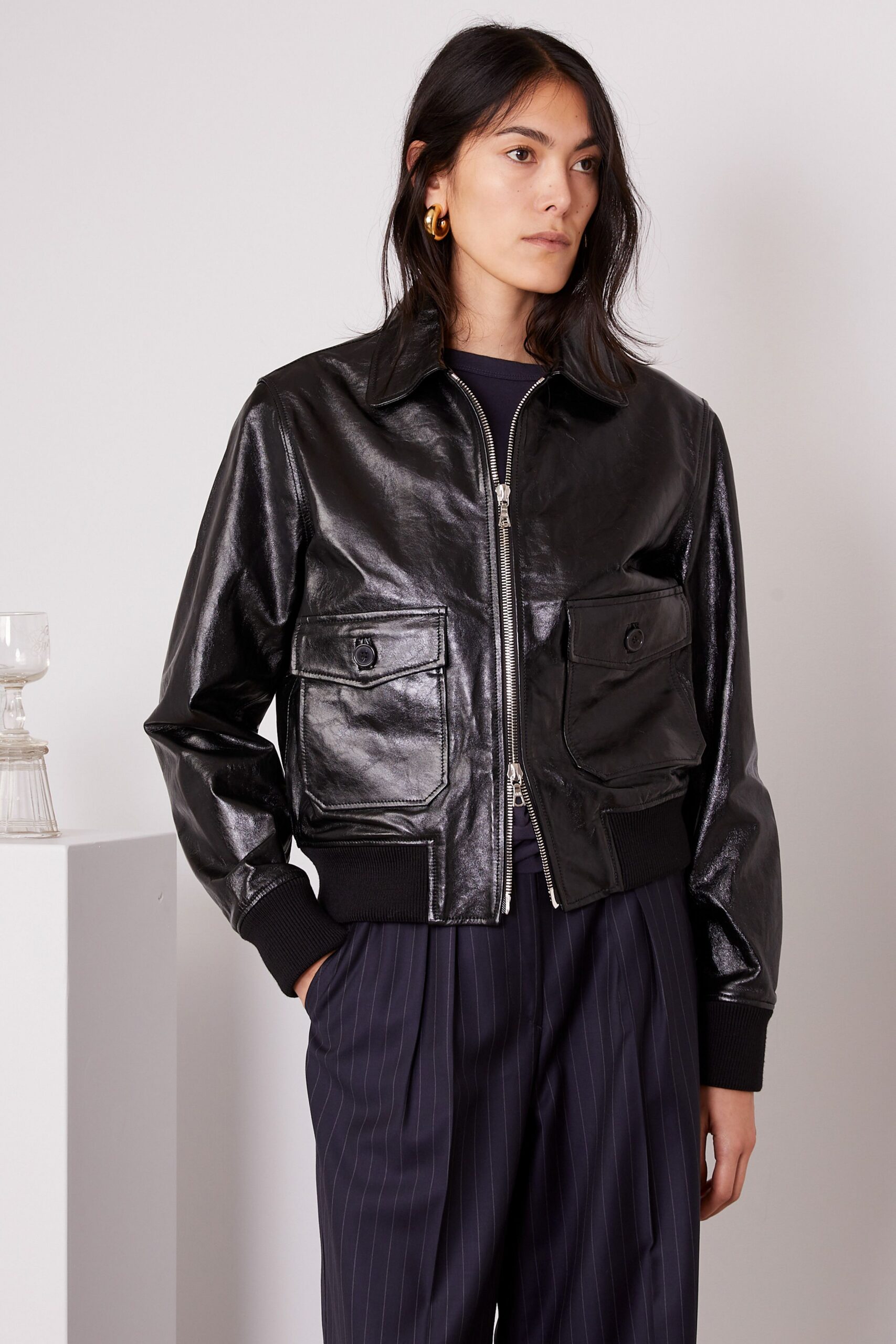 black leather fitted jacket with navy striped pants