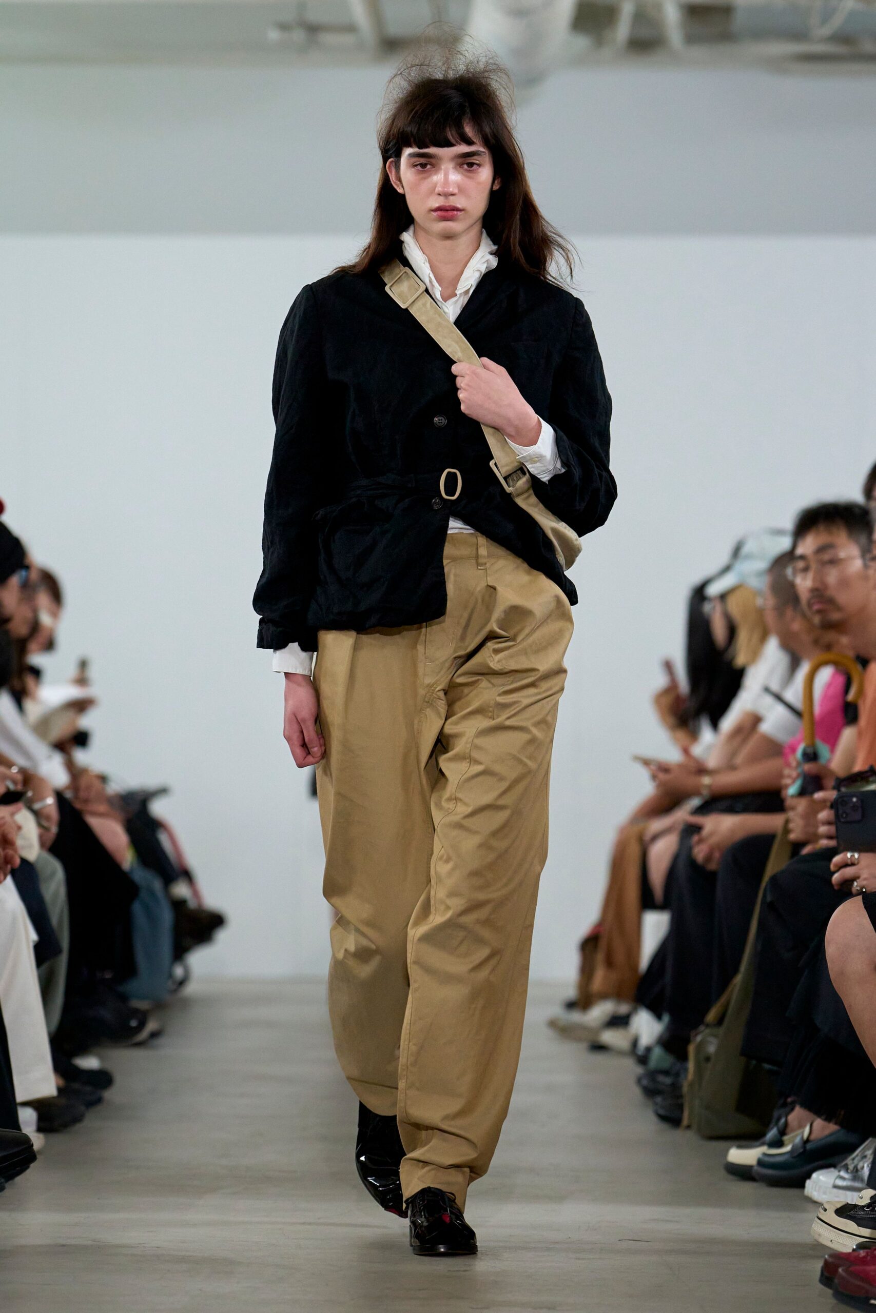 black faux-fur jacket with beige pants