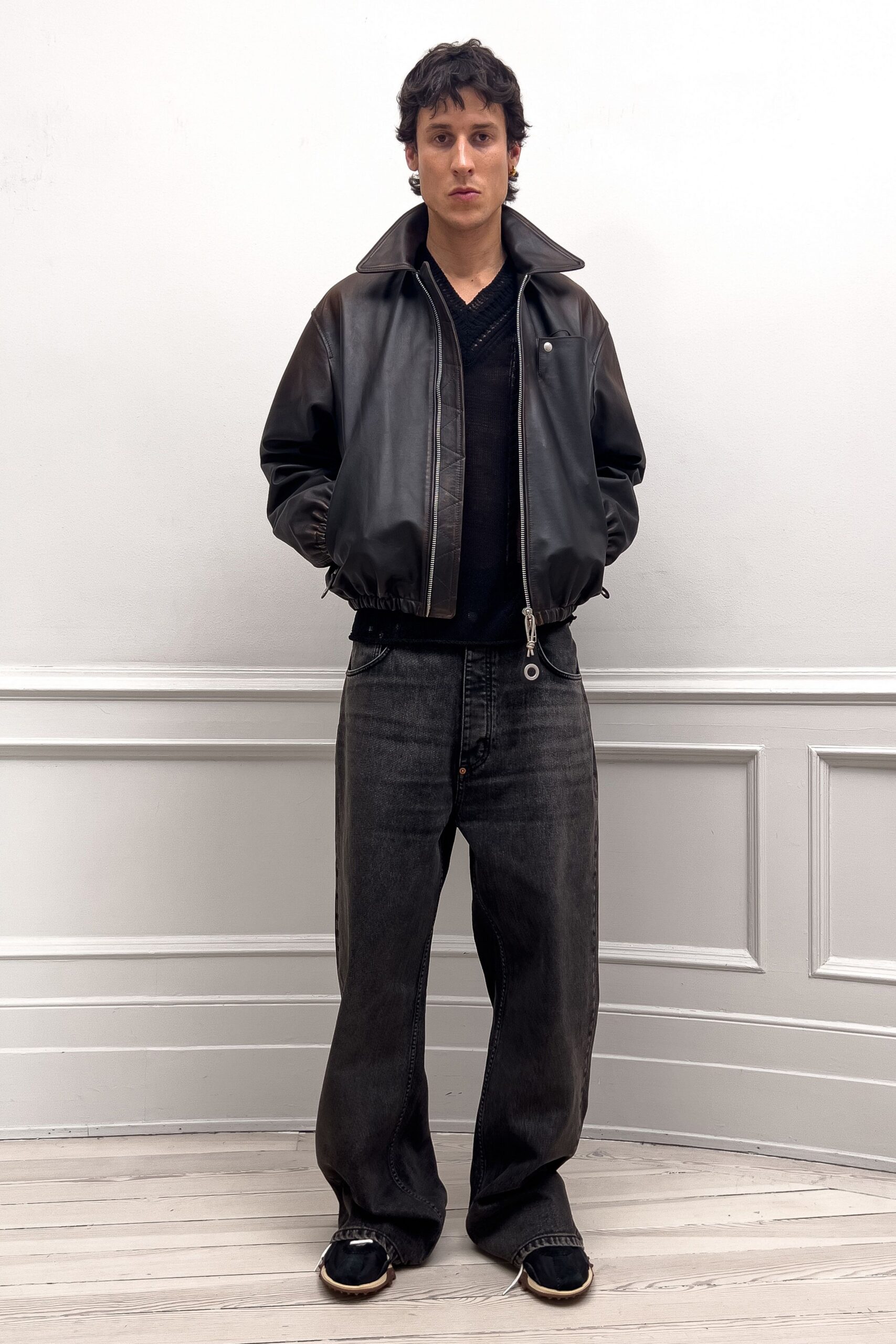 black leather jacket and gray pants