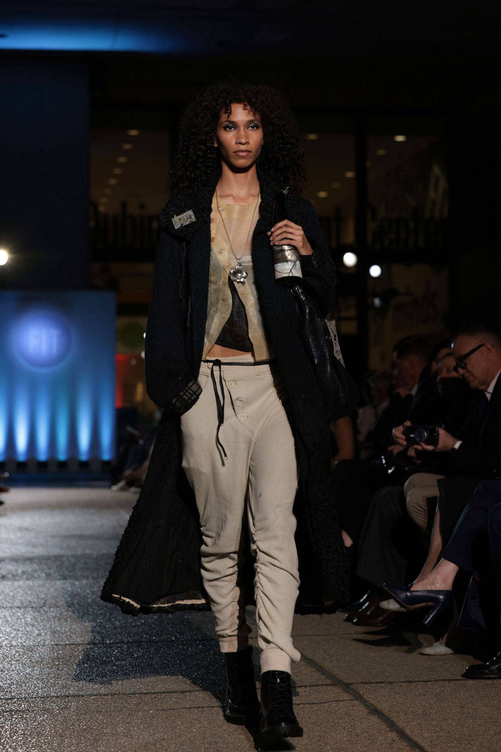 black wool coat beige top white pants