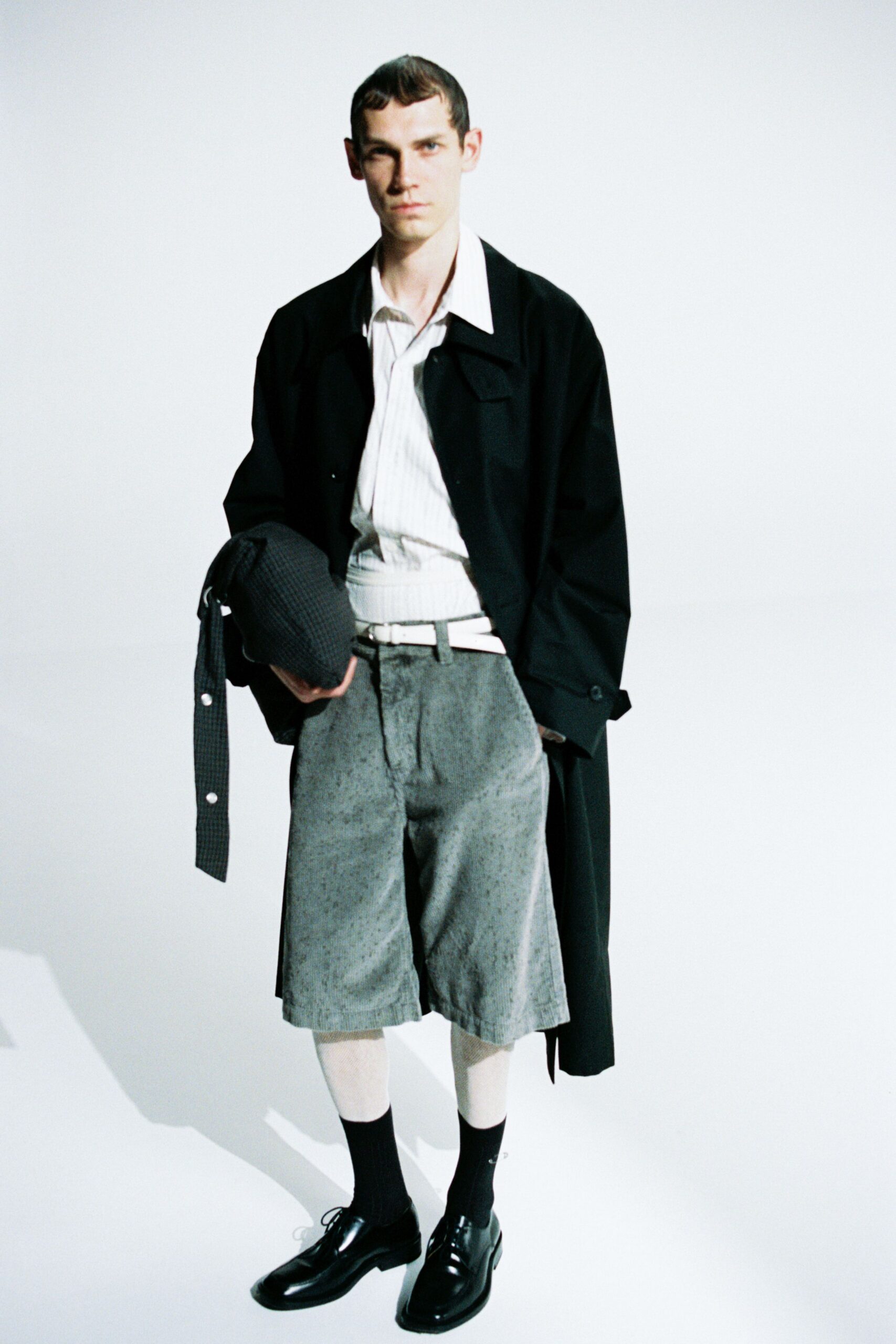 black coat white shirt gray shorts