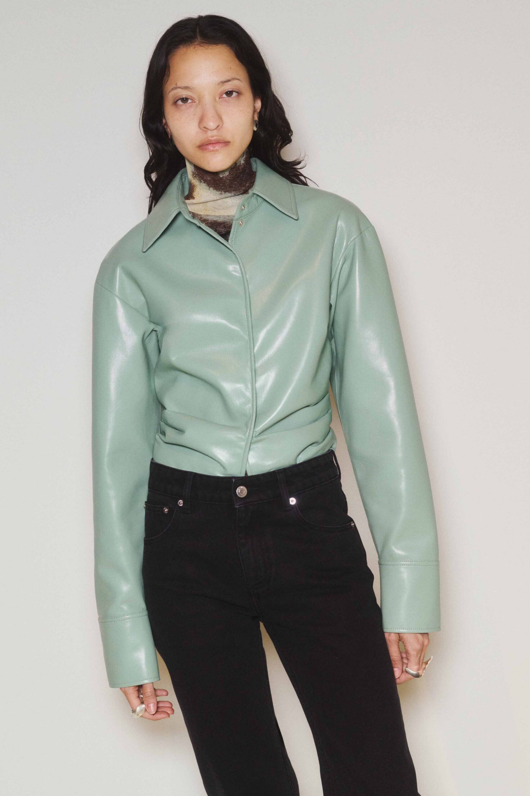 green leather fitted jacket and black pants