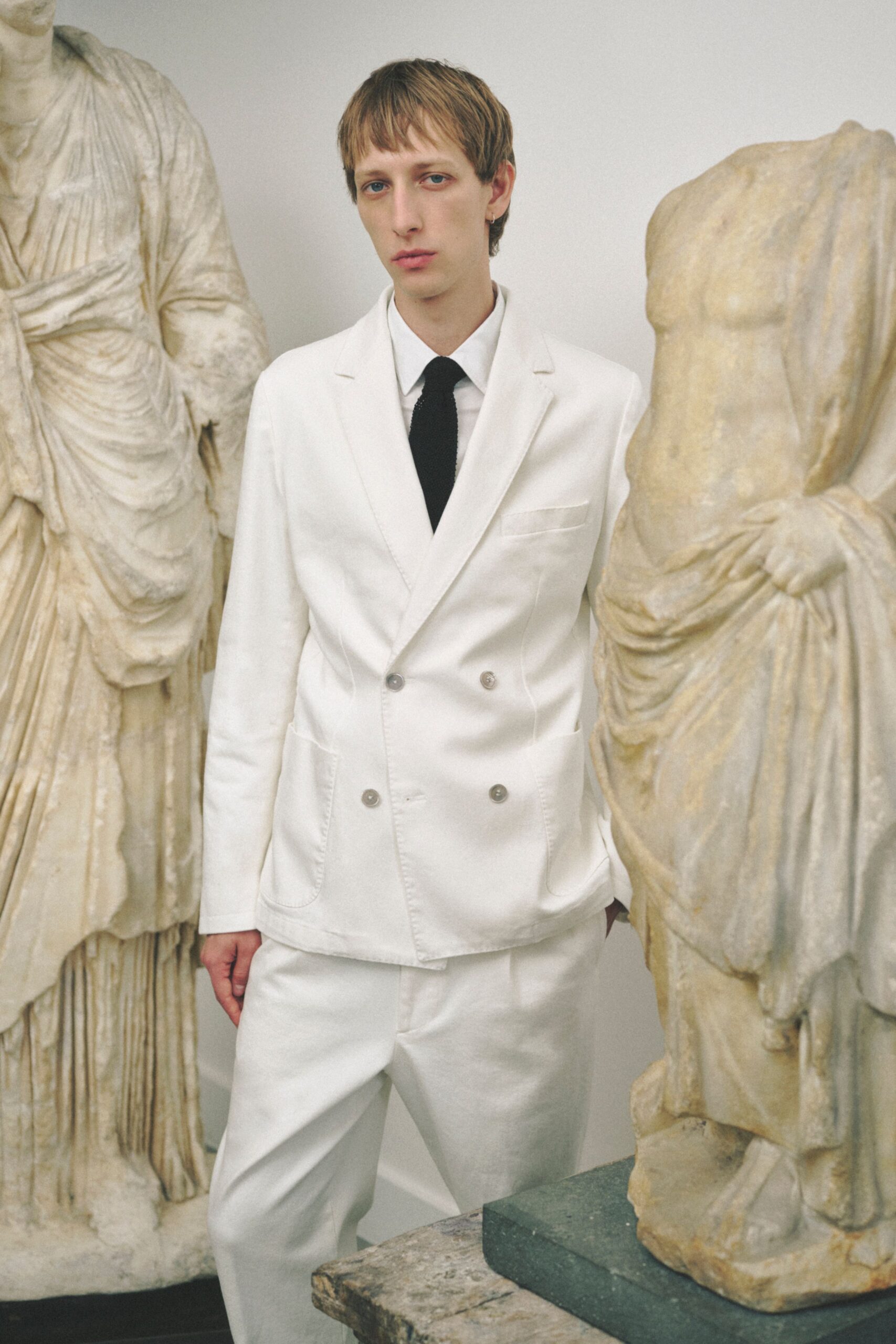 white tailored suit with black tie