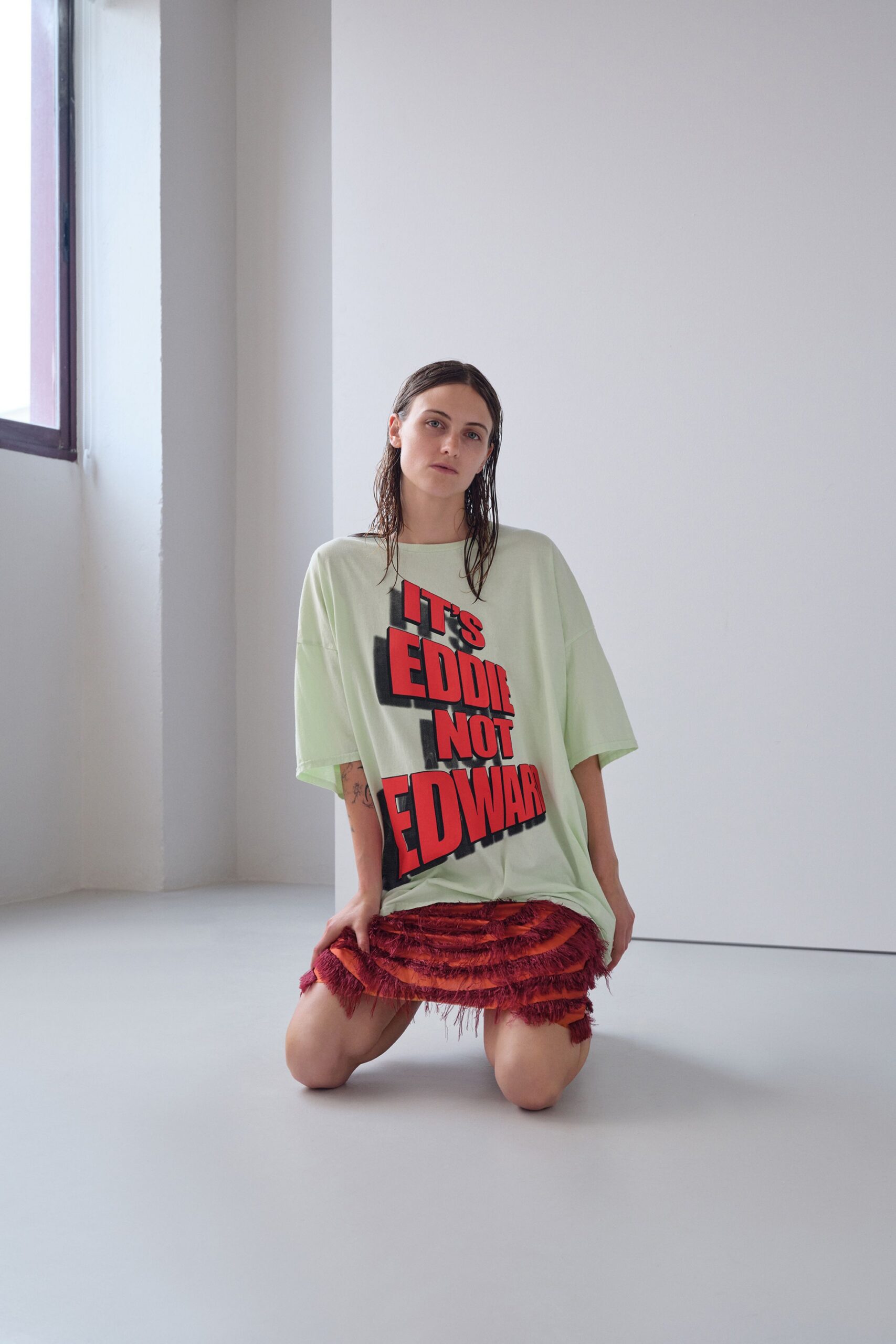 light green printed t-shirt and red fringed skirt