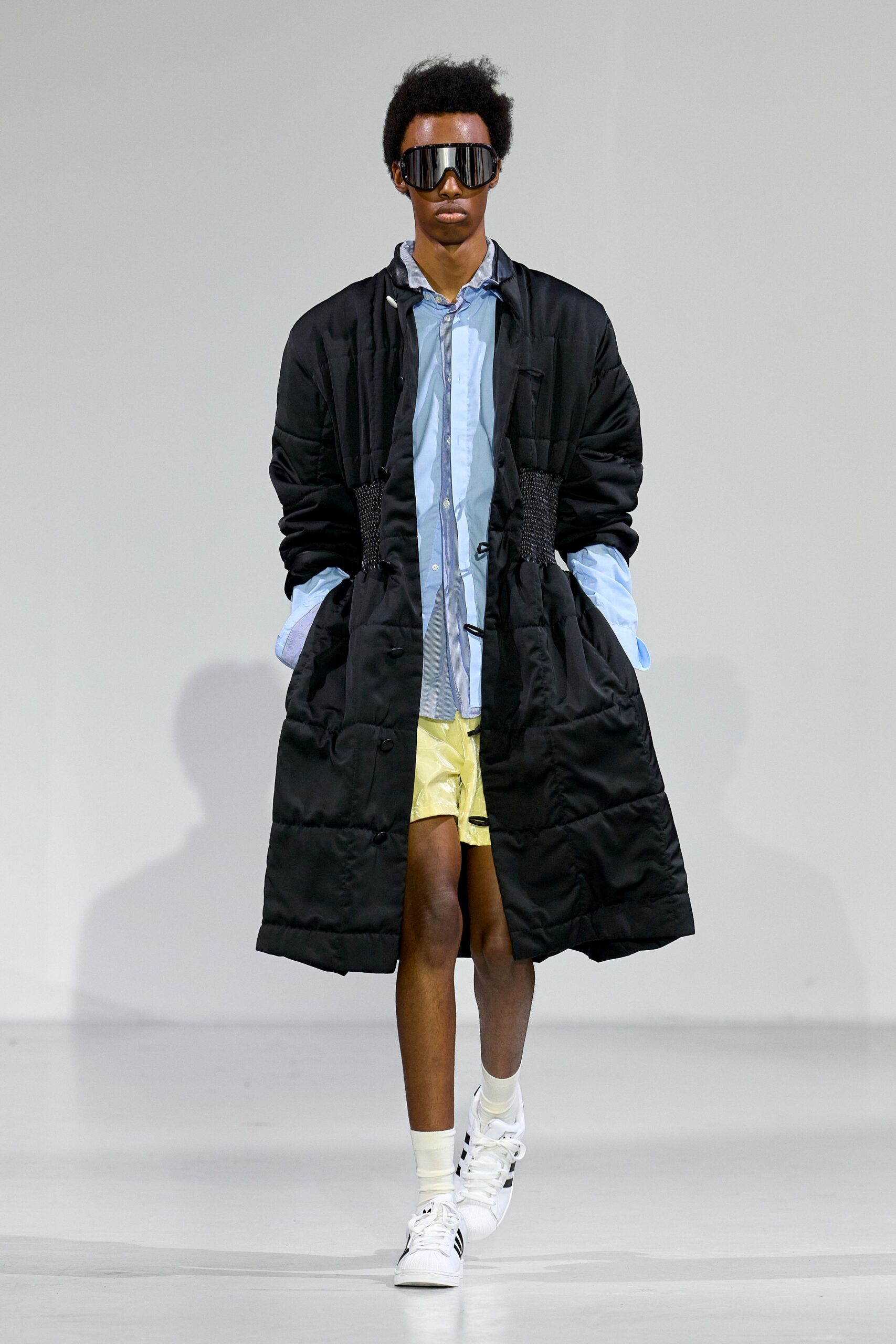 black coat blue shirt yellow shorts