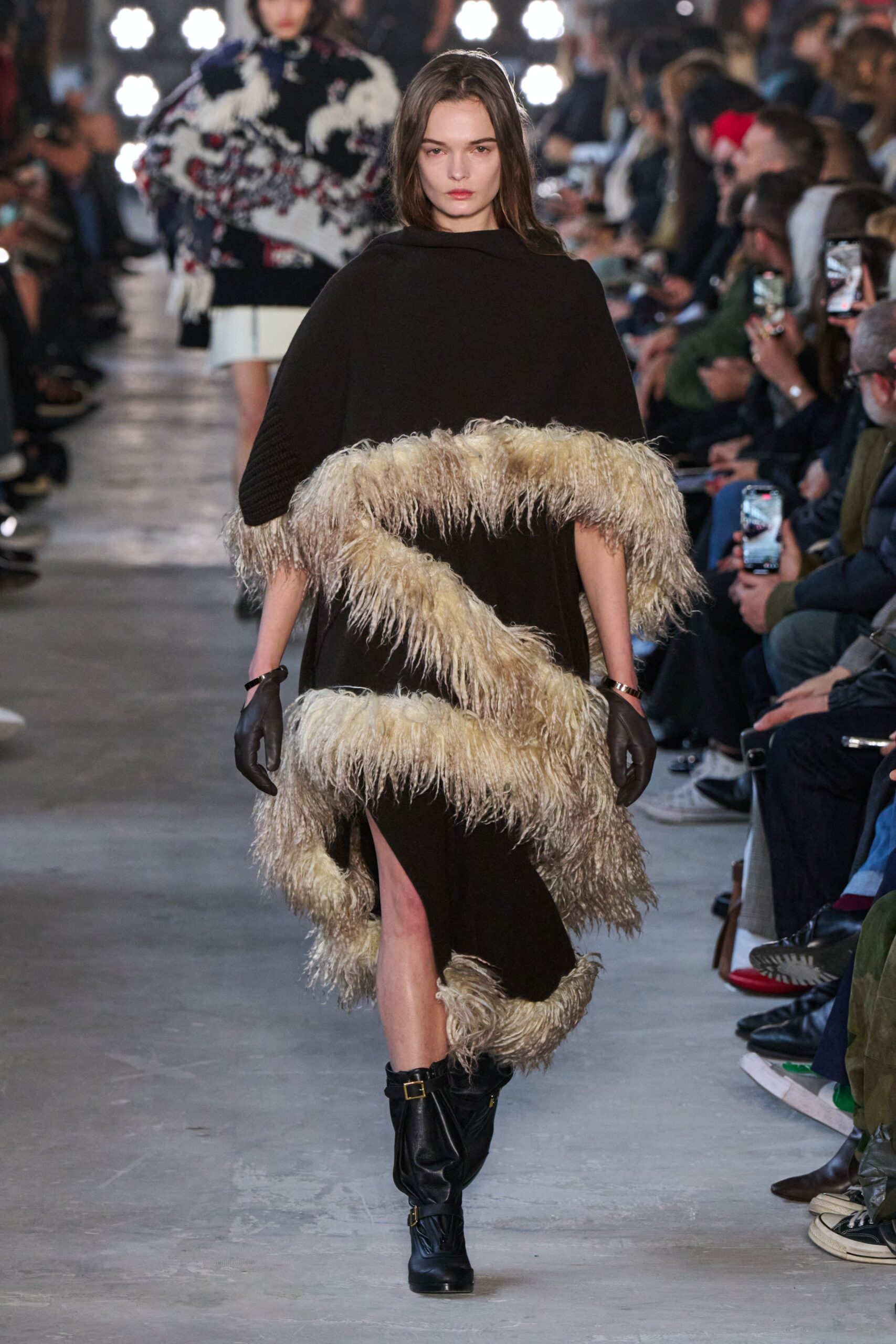 brown fringed cape with black gloves and boots