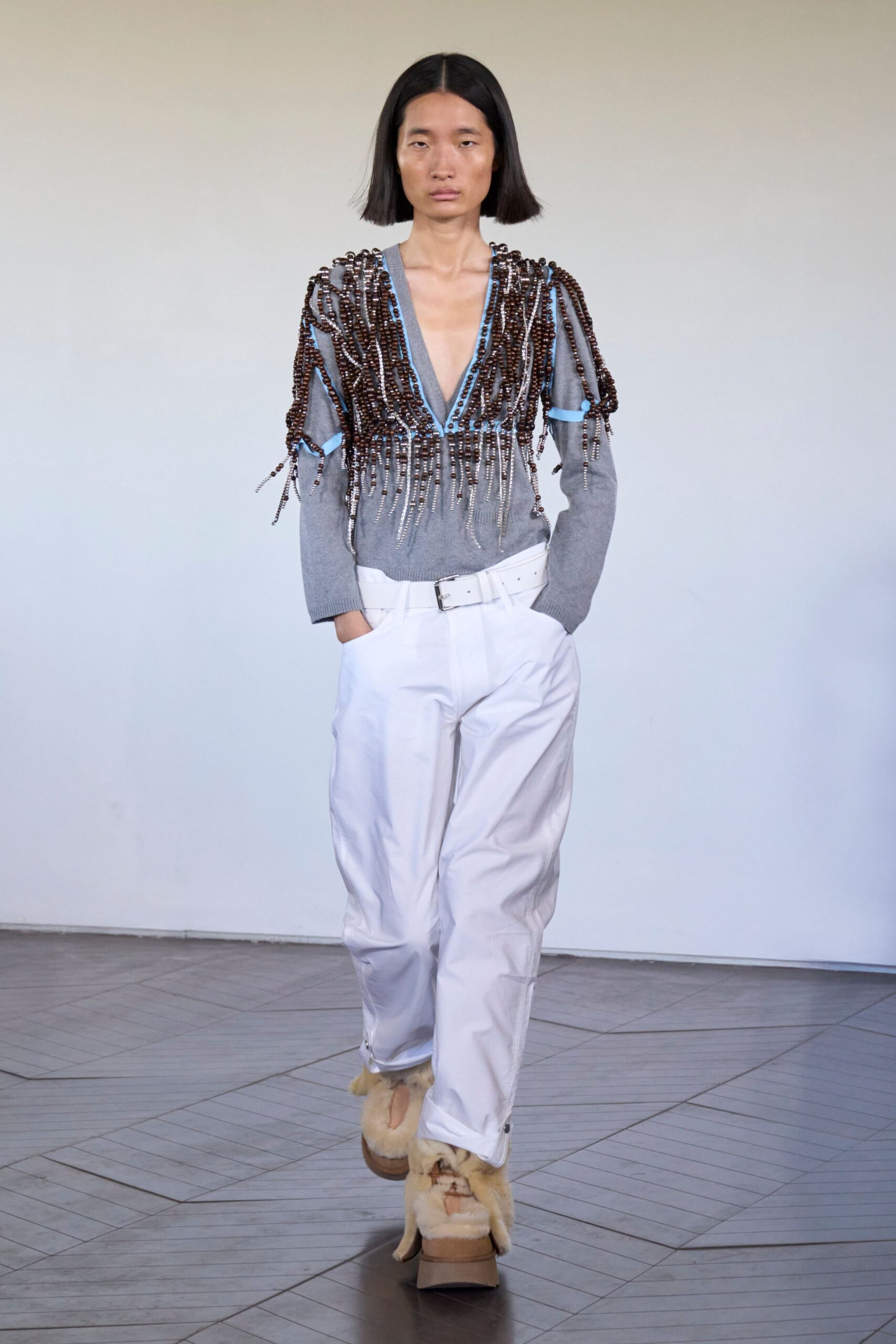 gray beaded top with white pants