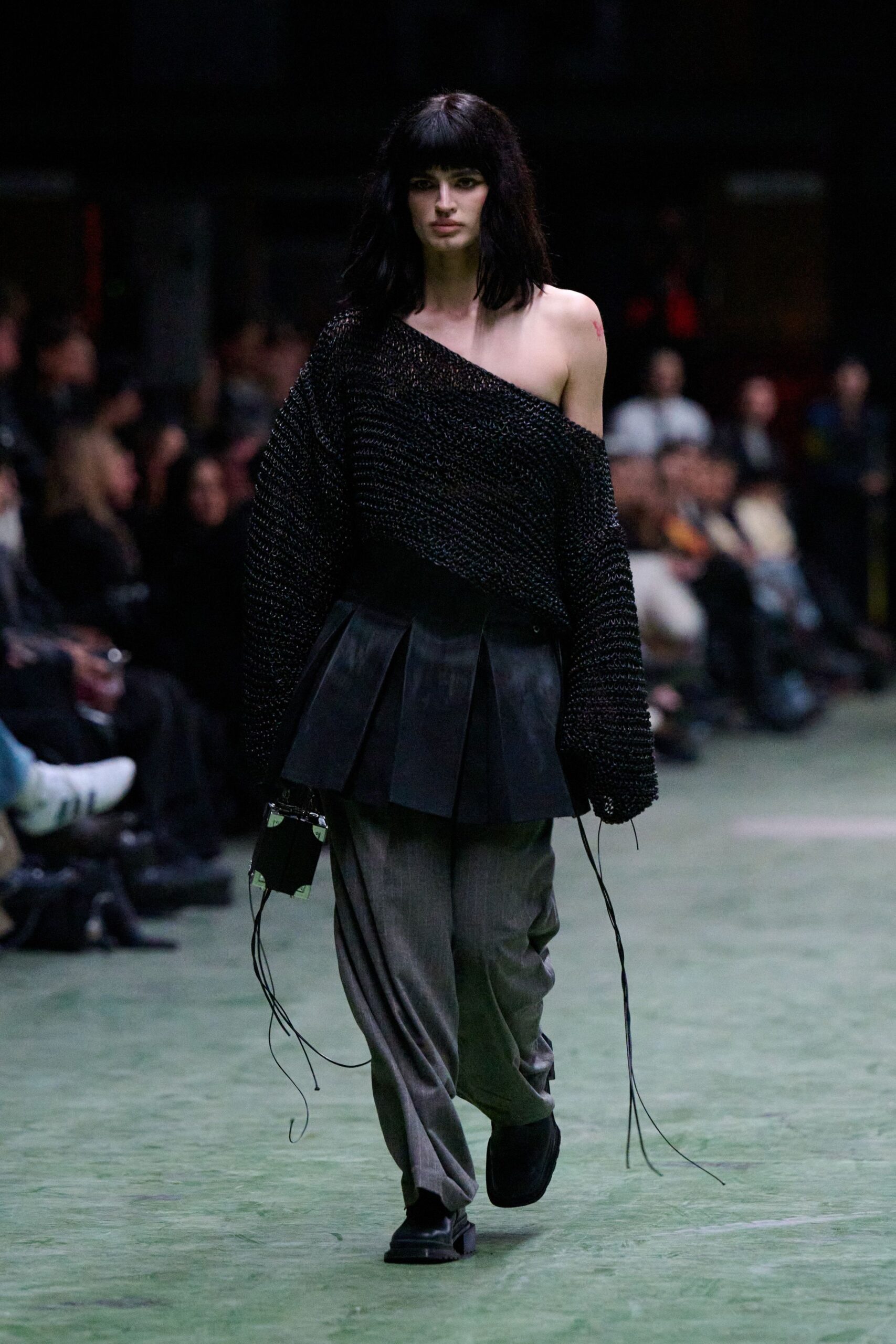 oversized black knit sweater with pleated leather skirt