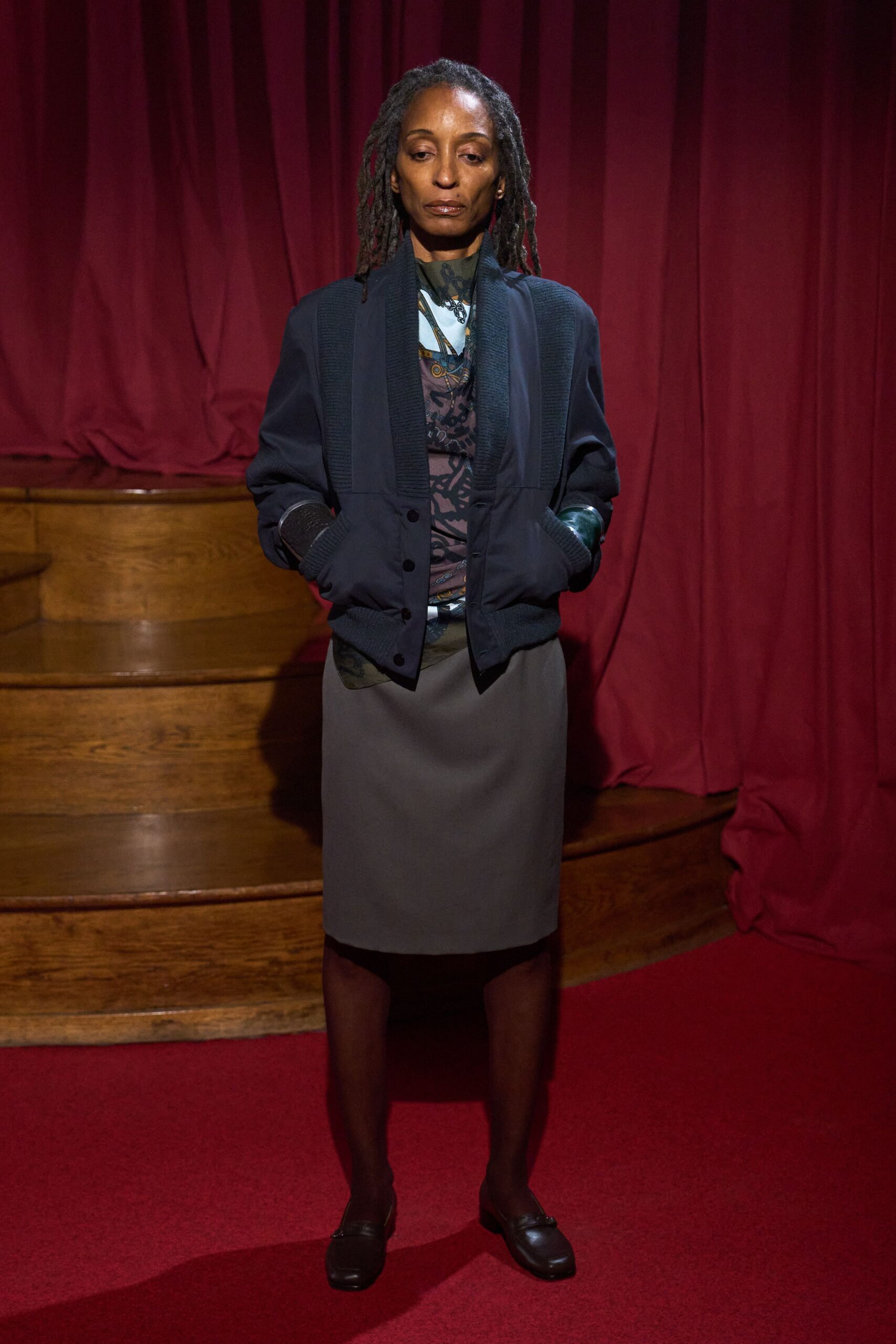 black jacket blue top gray skirt