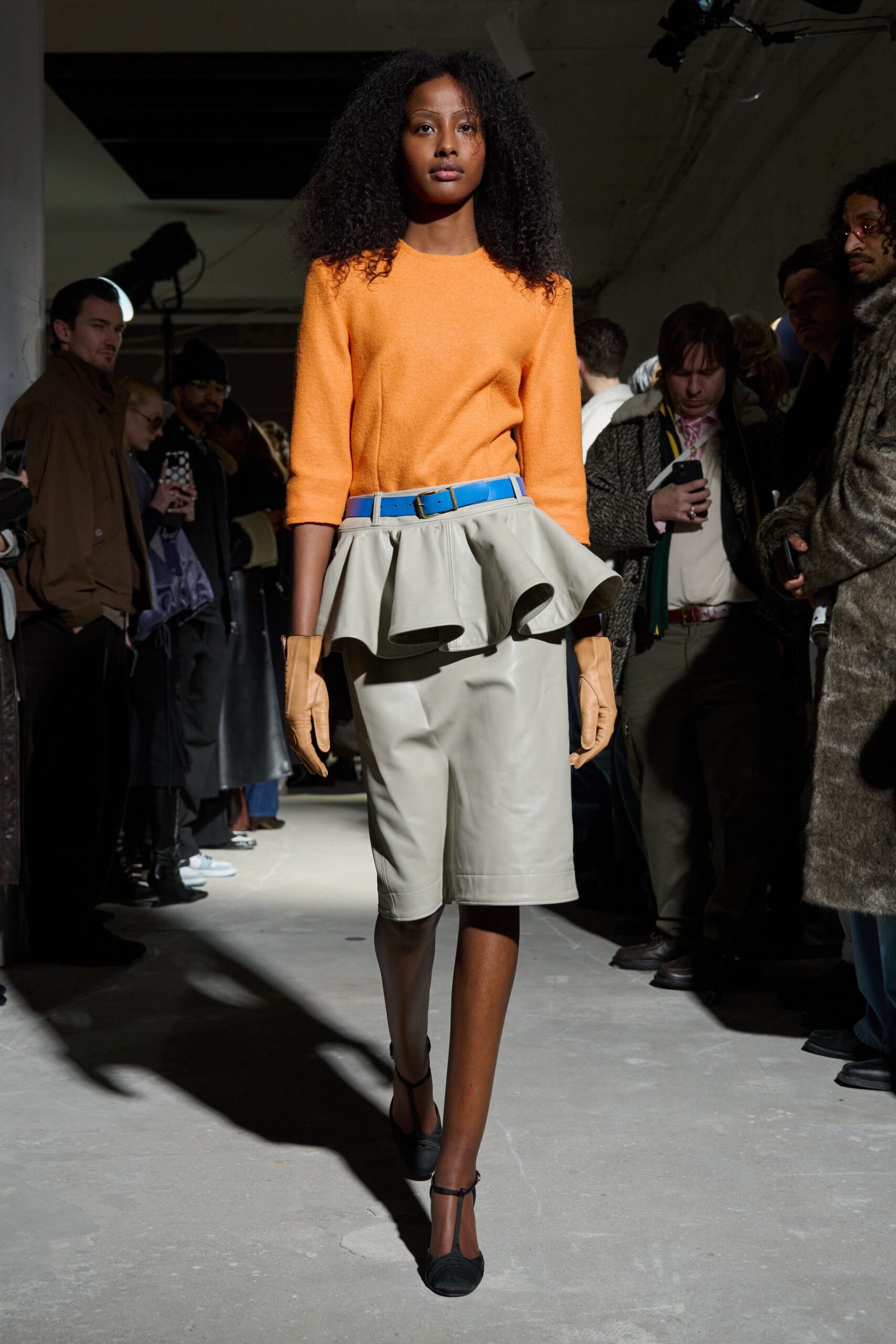 orange fitted top with beige skirt