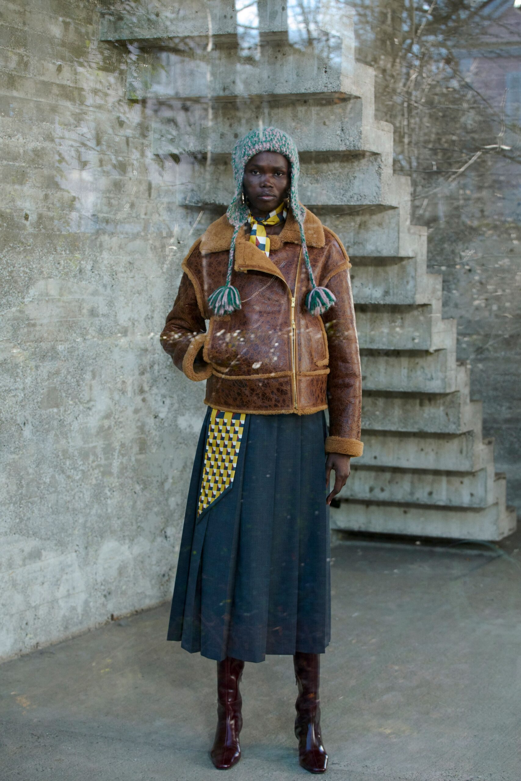 brown leather jacket with gray skirt