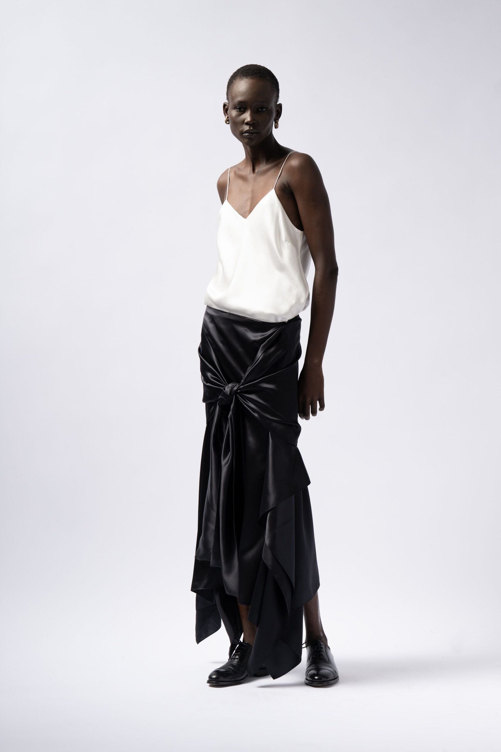 white silk sleeveless top and black skirt