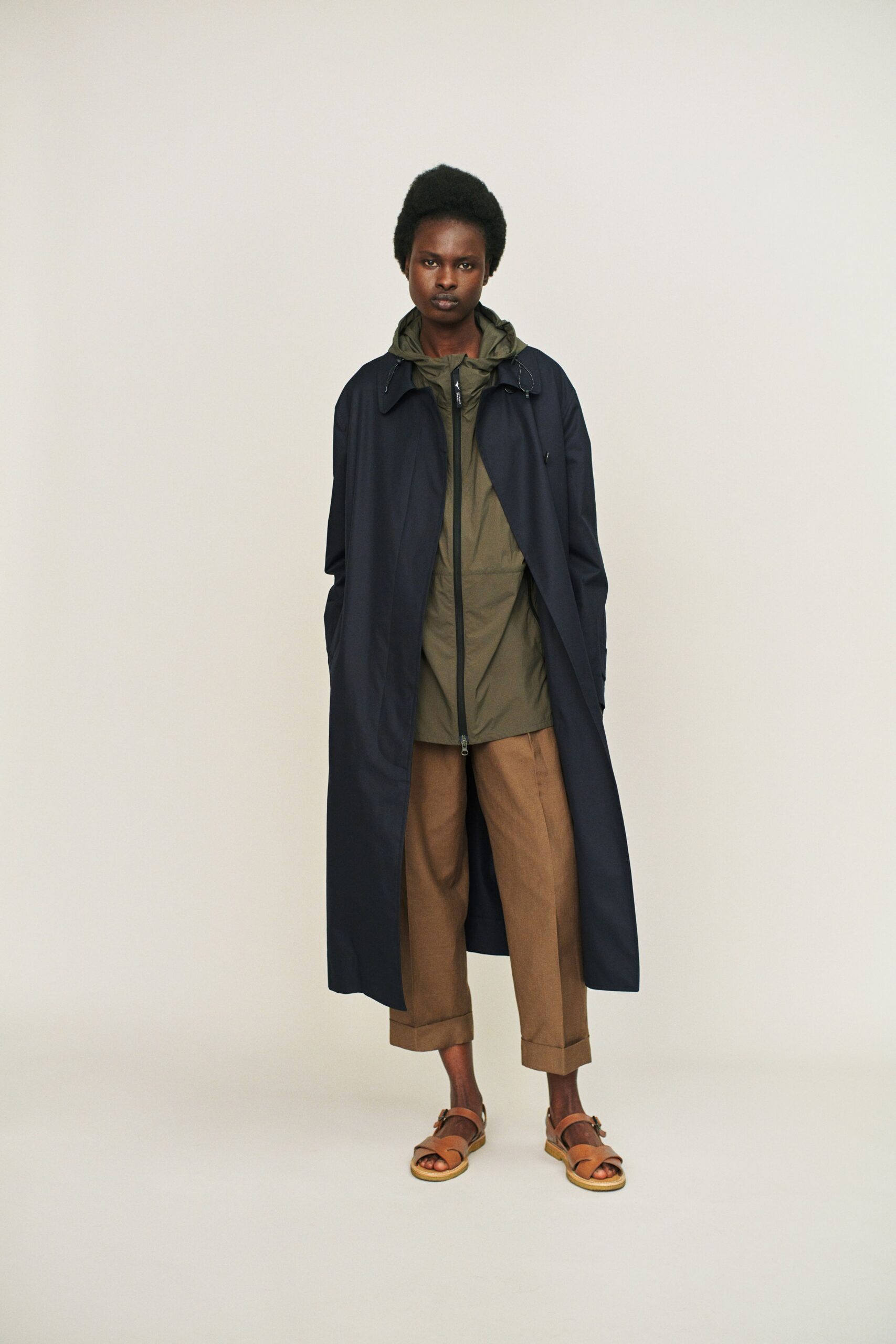 navy coat olive jacket brown pants tan sandals