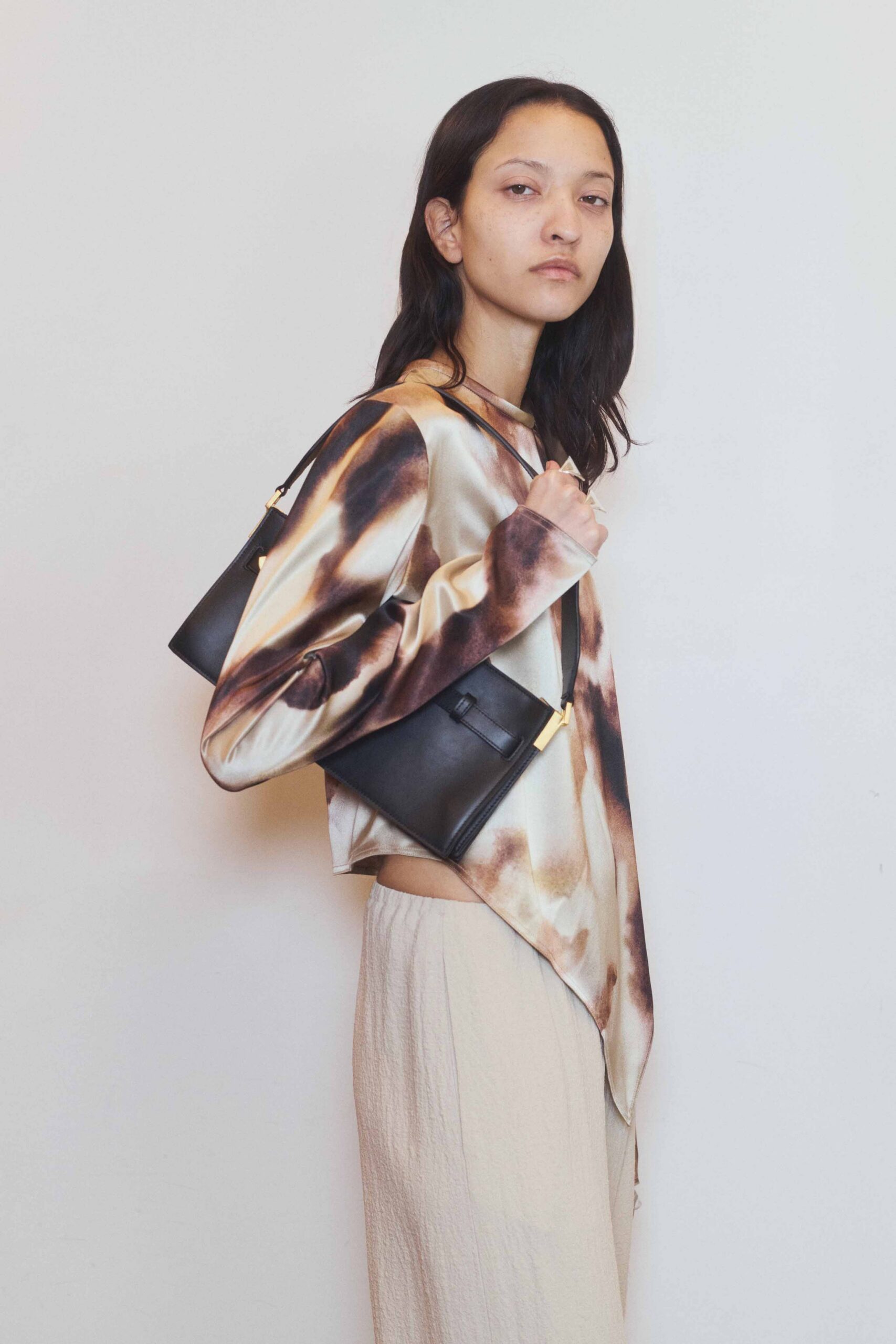 beige printed top with black bag