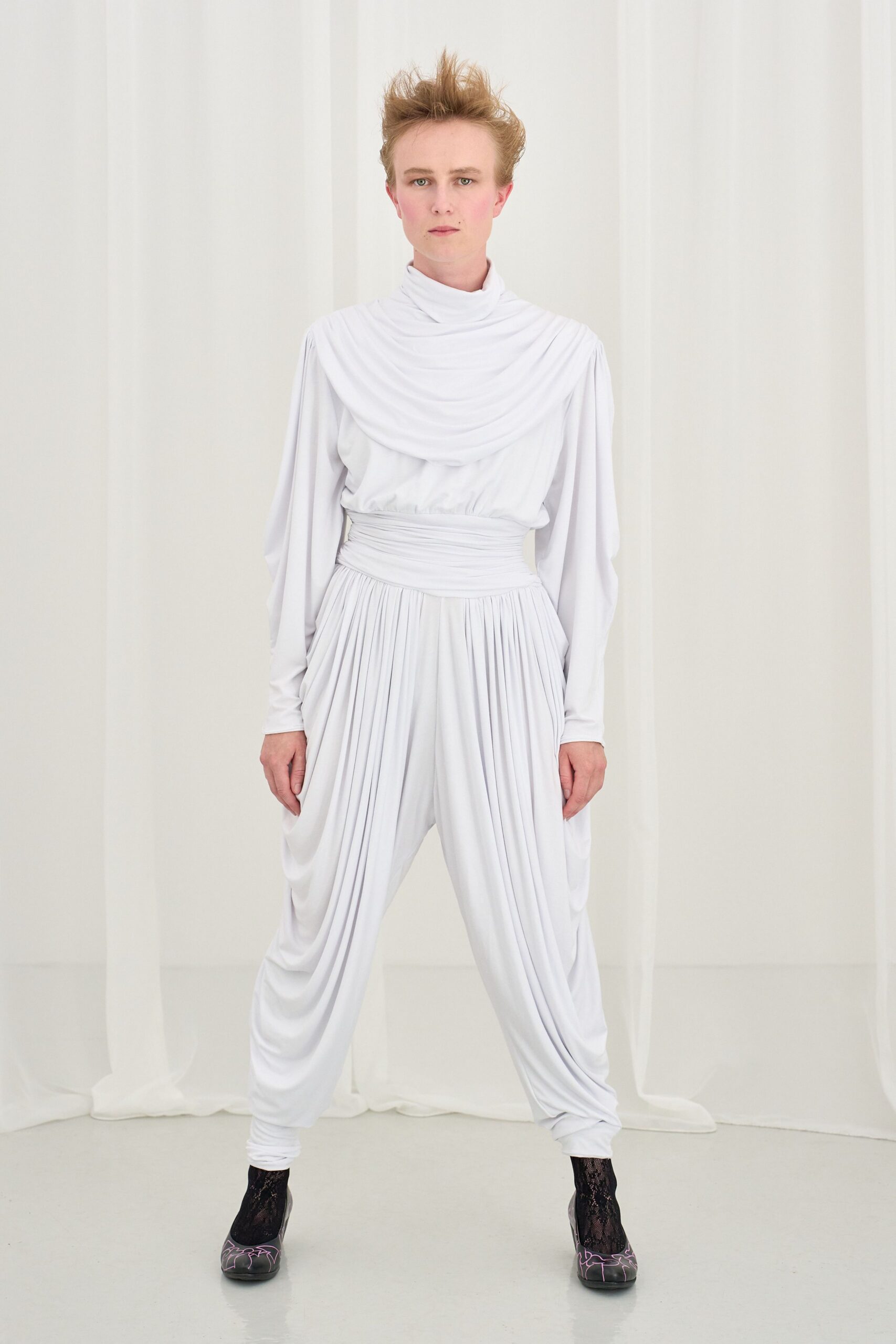 white pleated jumpsuit with black shoes