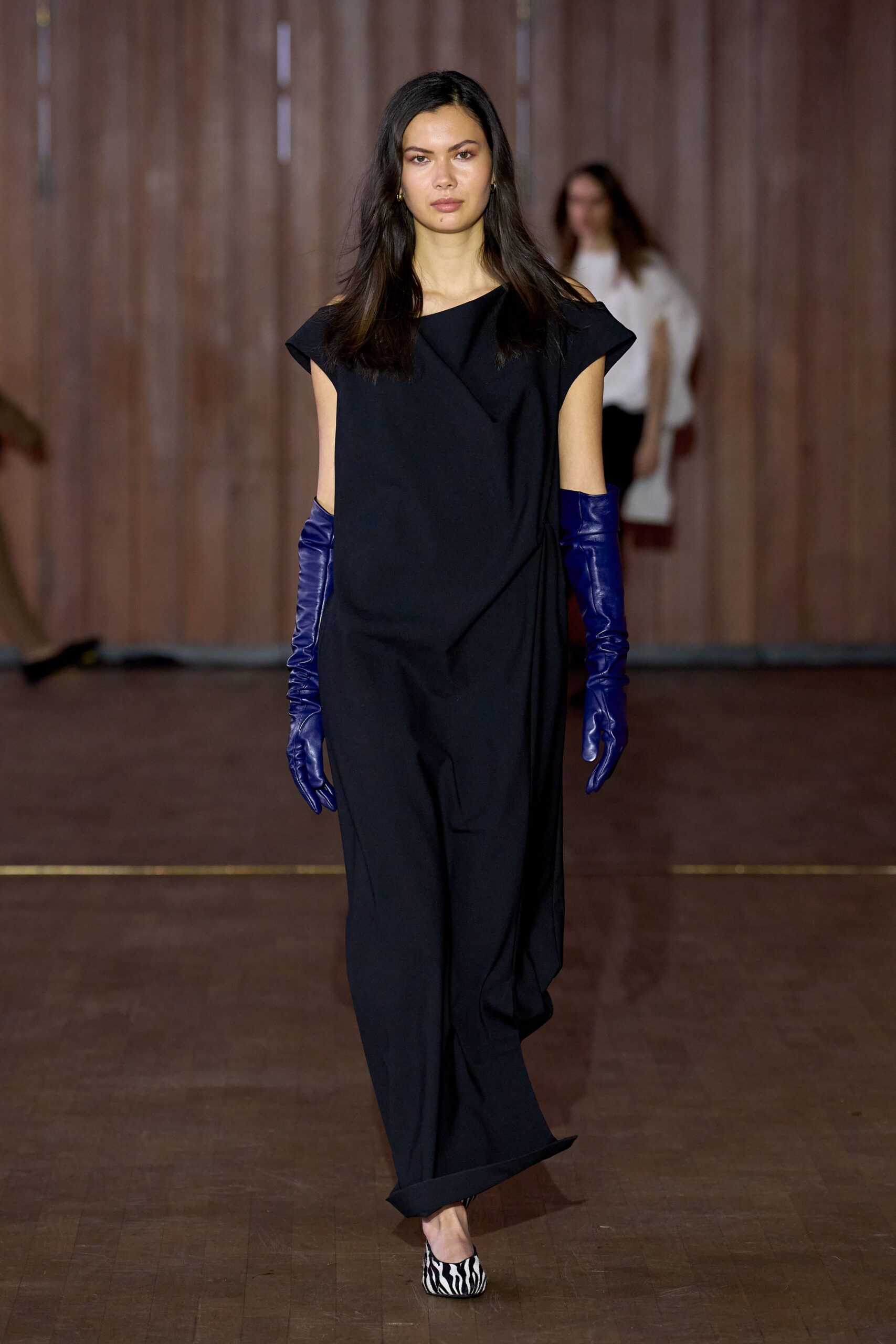 black relaxed jumpsuit with blue gloves