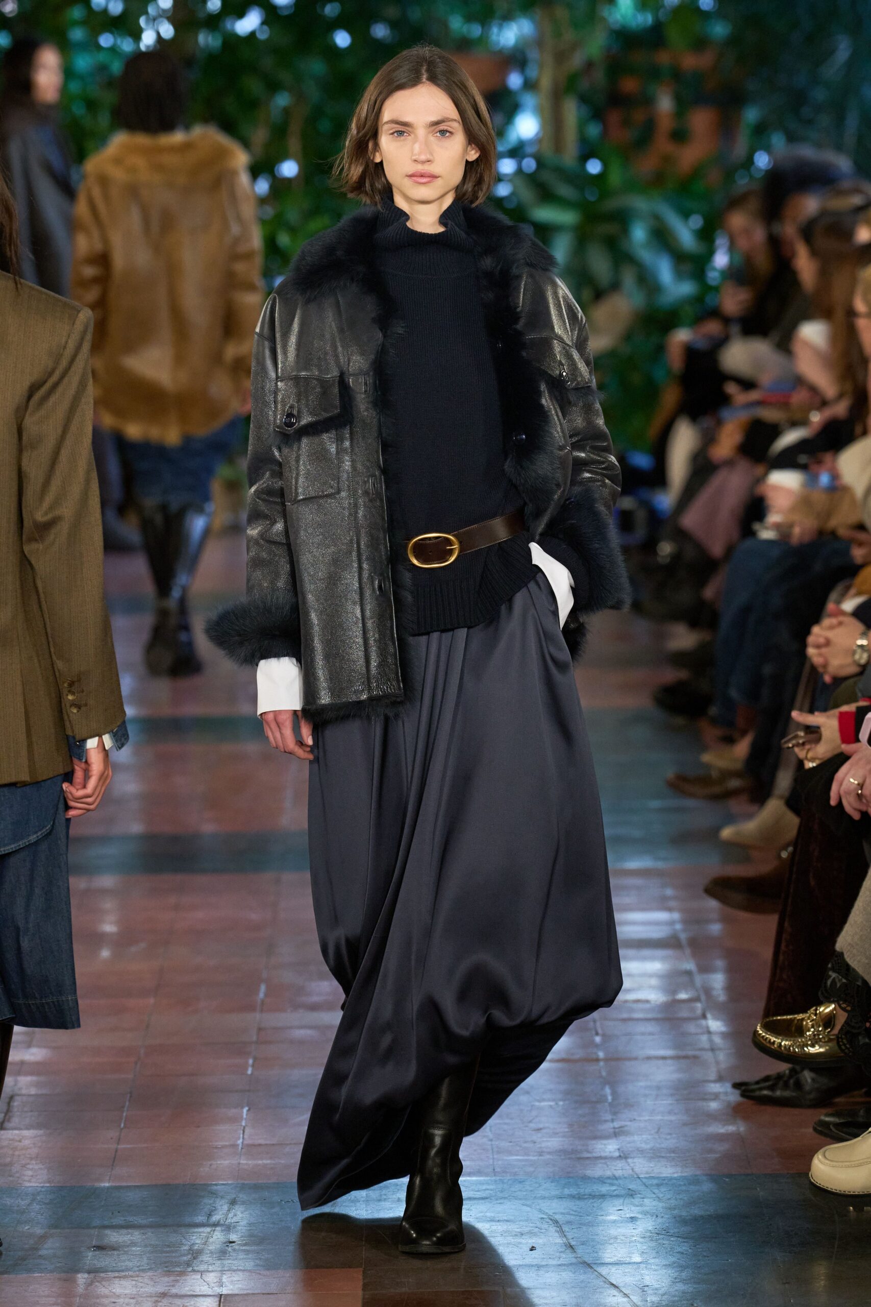 black leather coat and blue pleated skirt