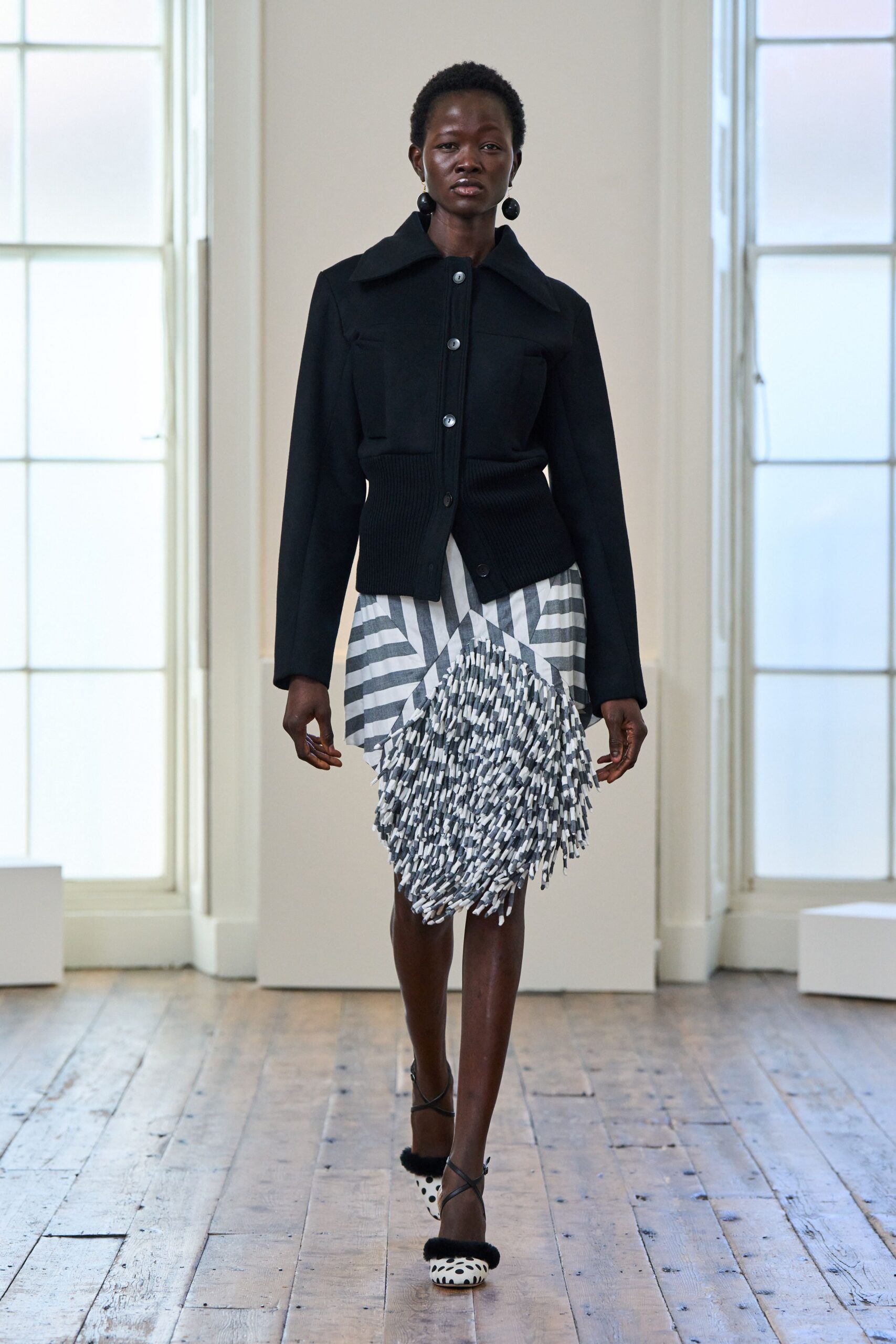 black fitted jacket with pleated skirt