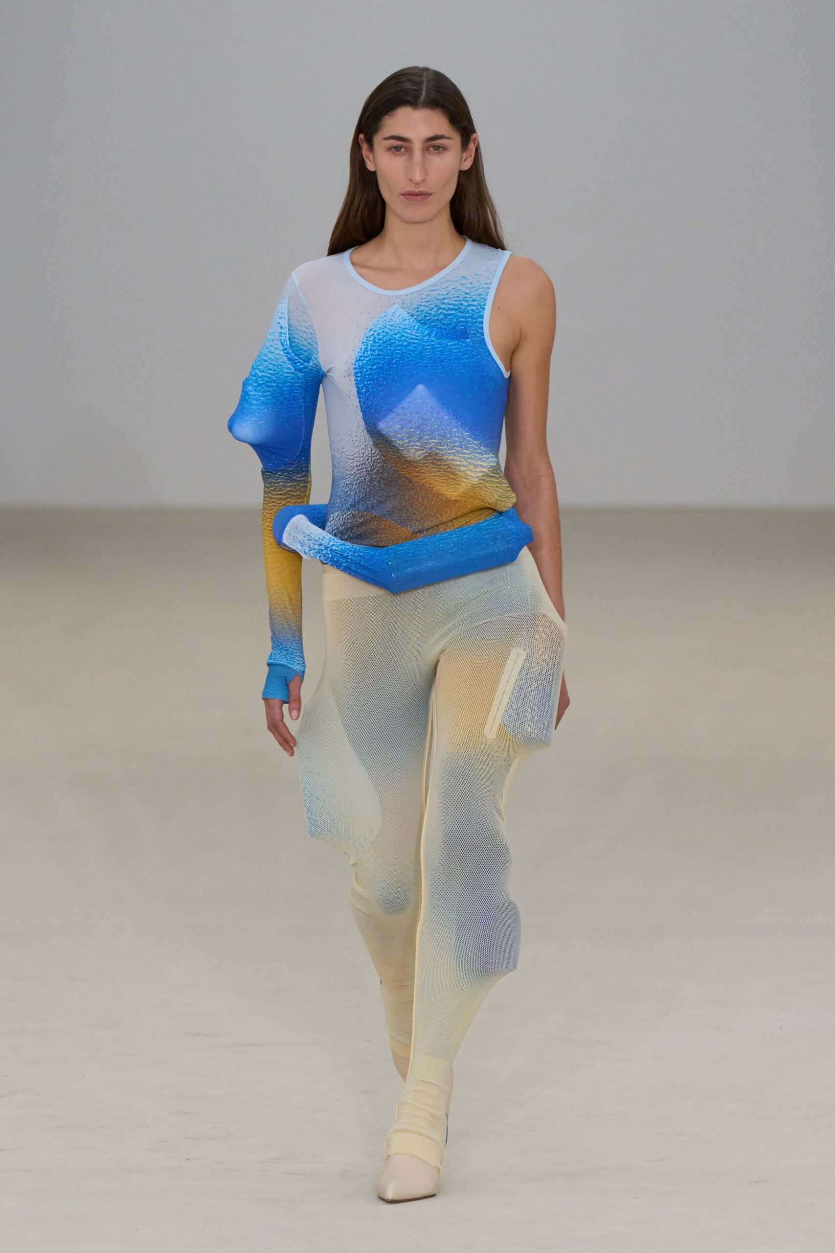 blue and orange fitted top with beige pants