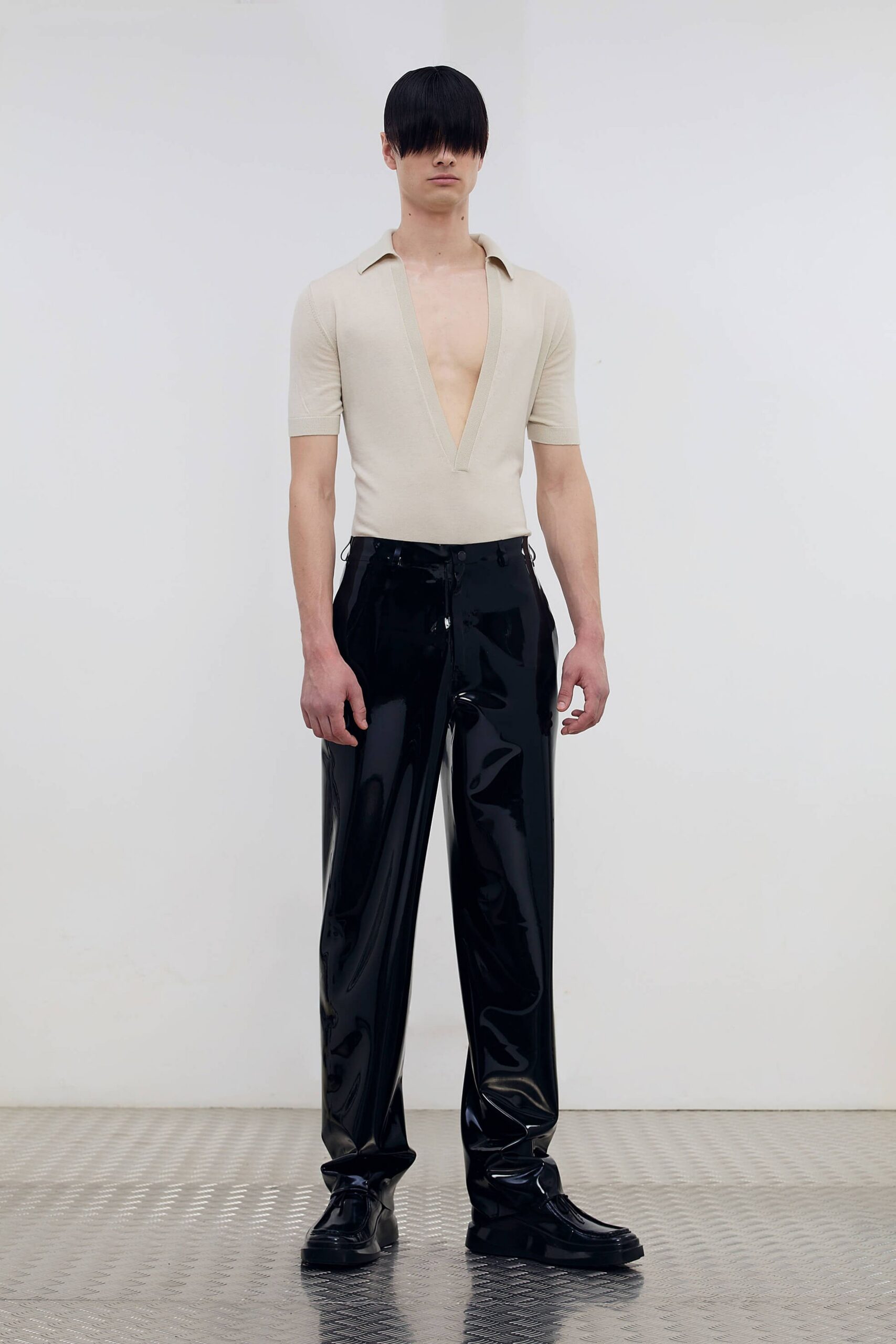 beige fitted top black vinyl pants
