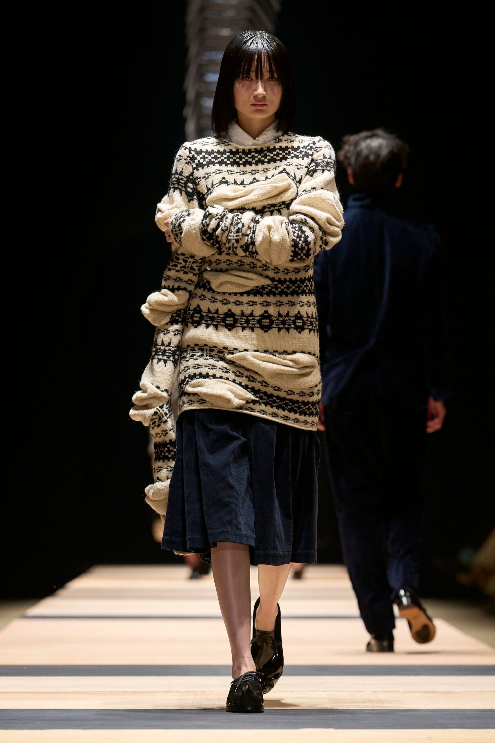 beige embroidered sweater with navy skirt