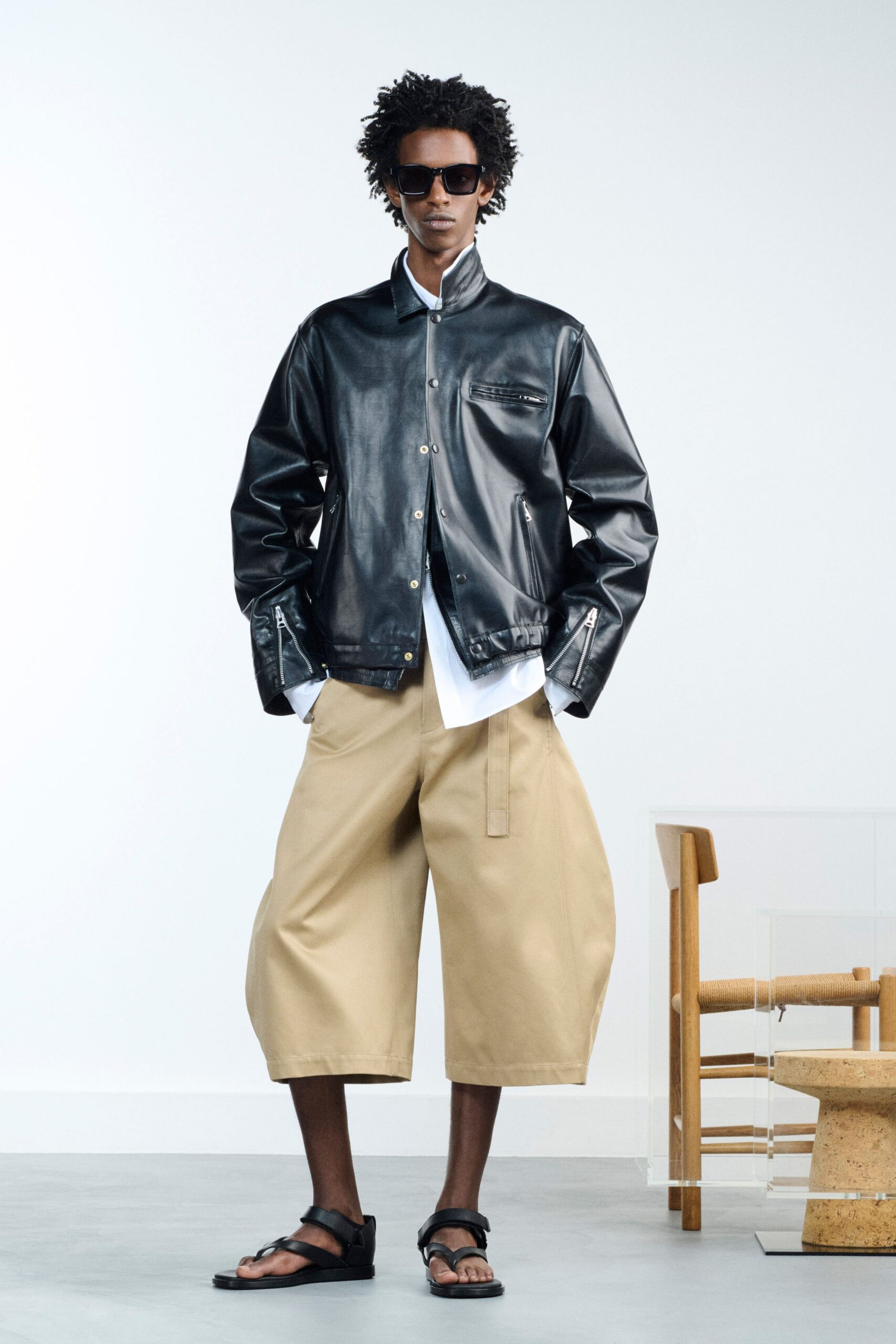 black leather jacket with beige pants