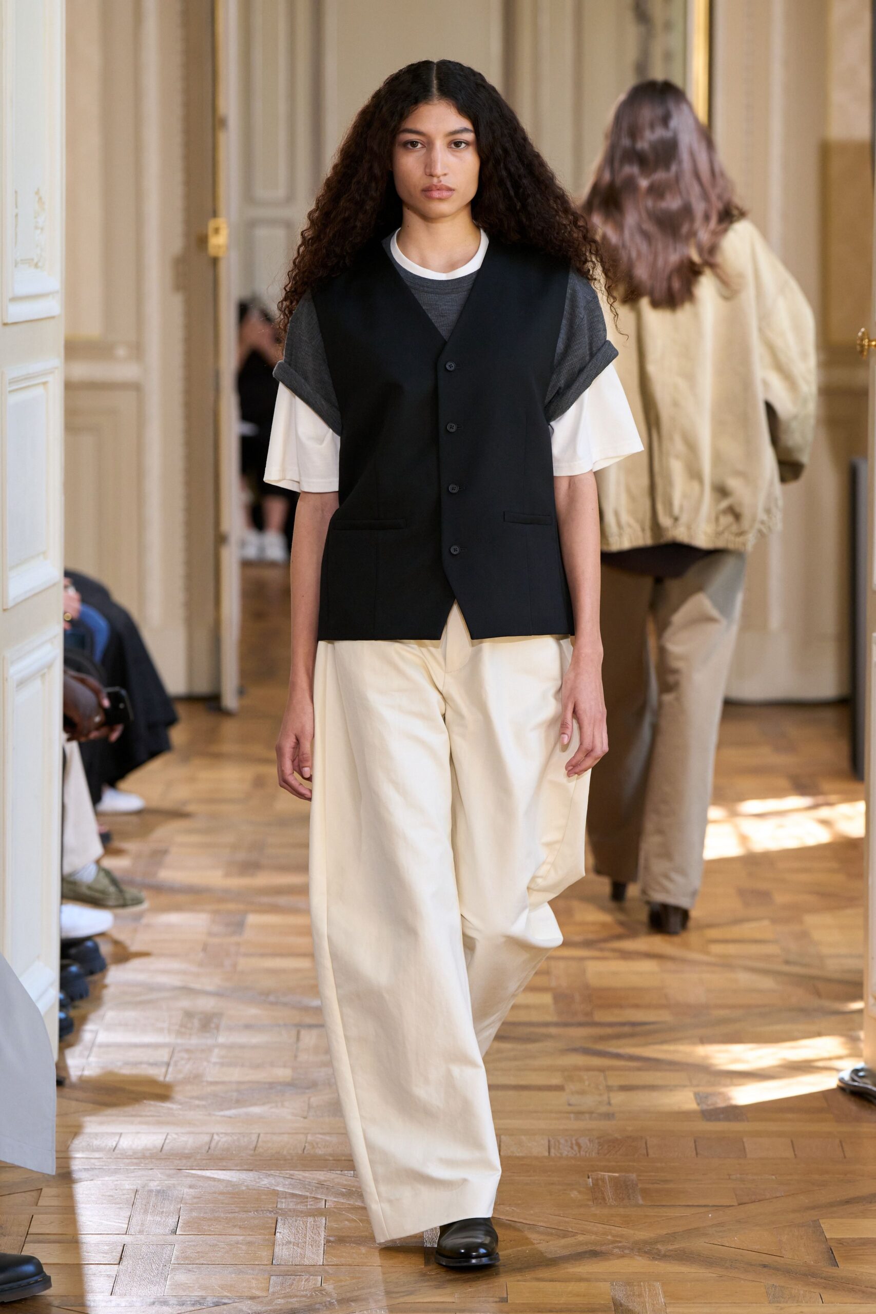 black vest white t-shirt beige pants