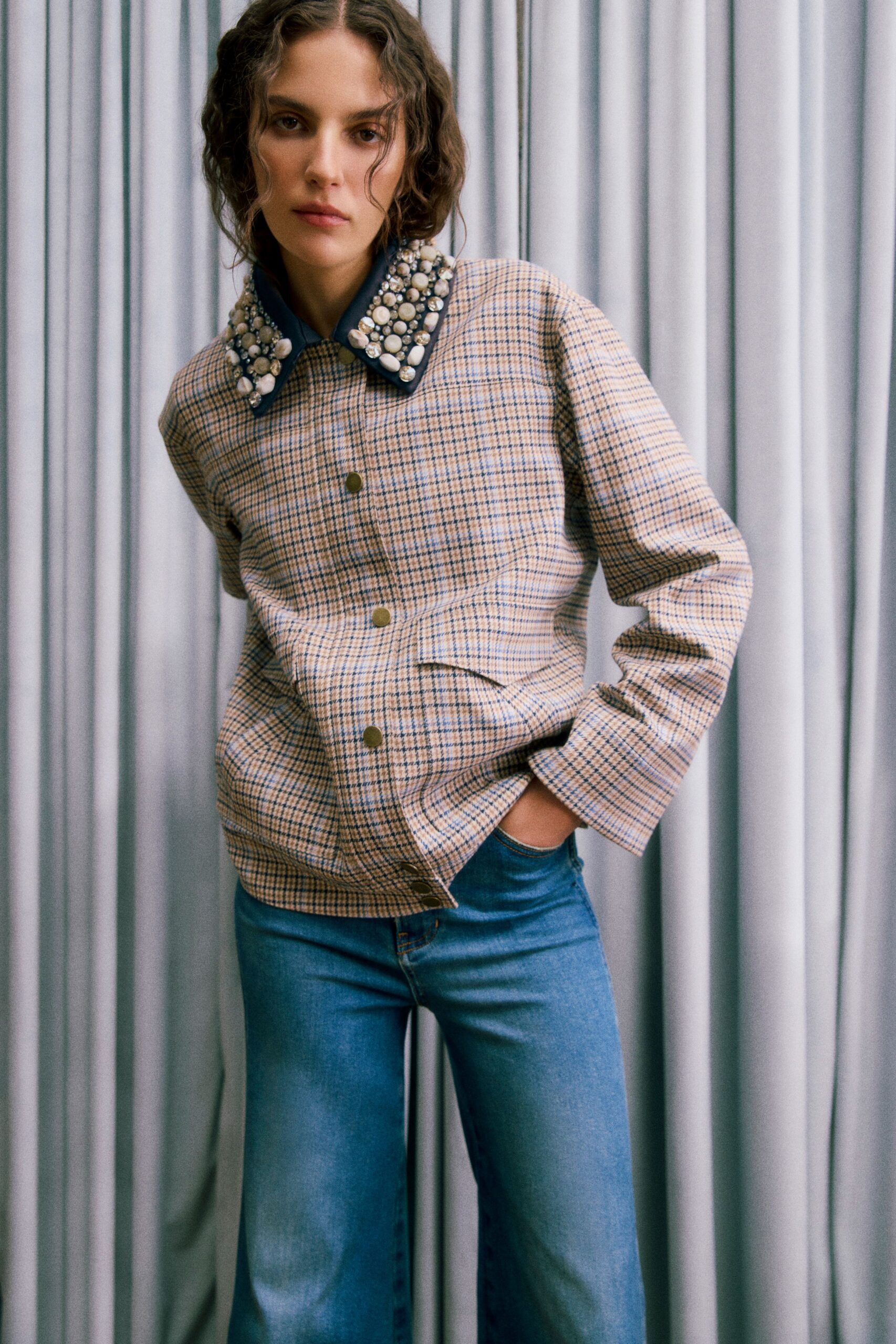 beige checked jacket with blue jeans