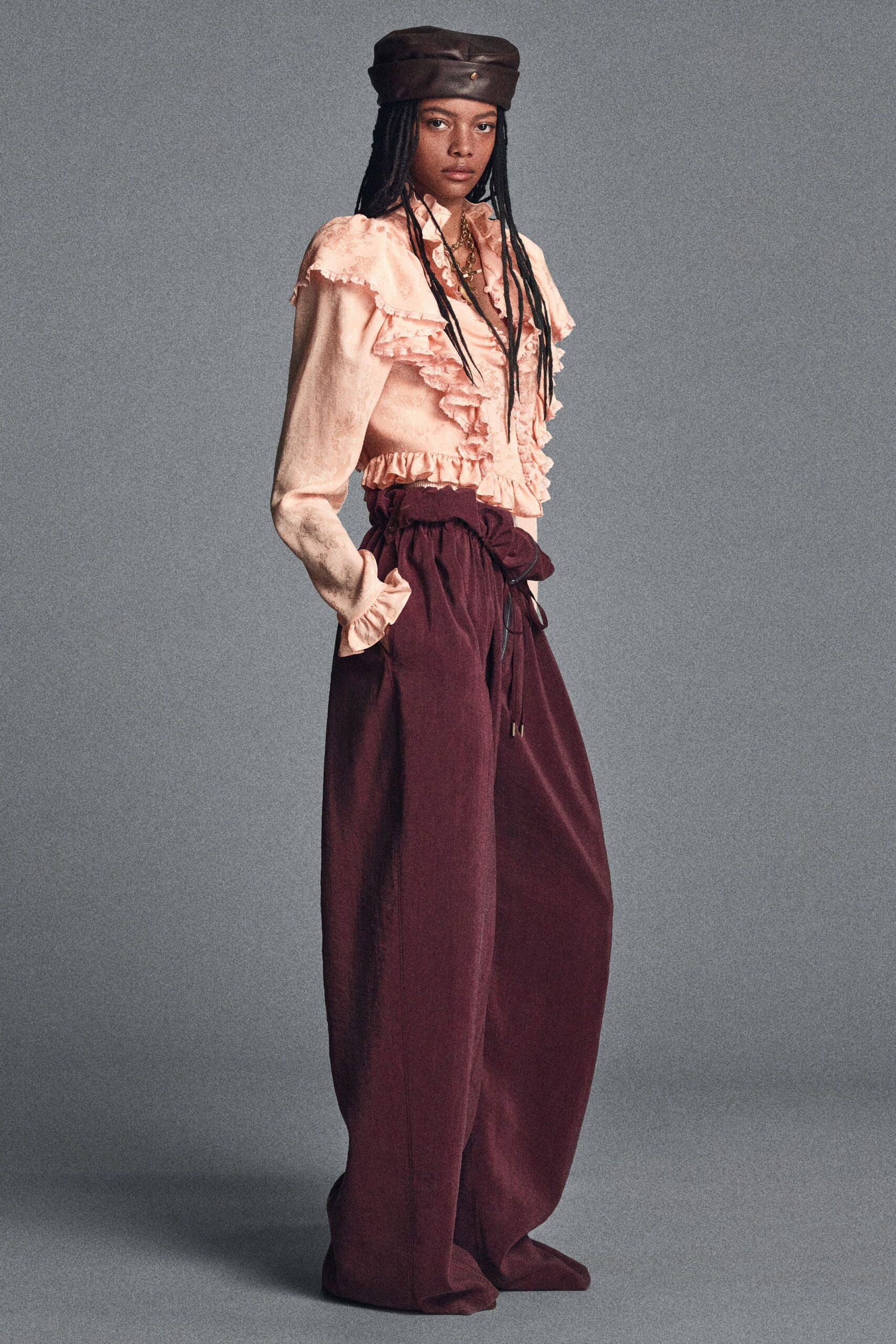 pink ruffled blouse with maroon pants