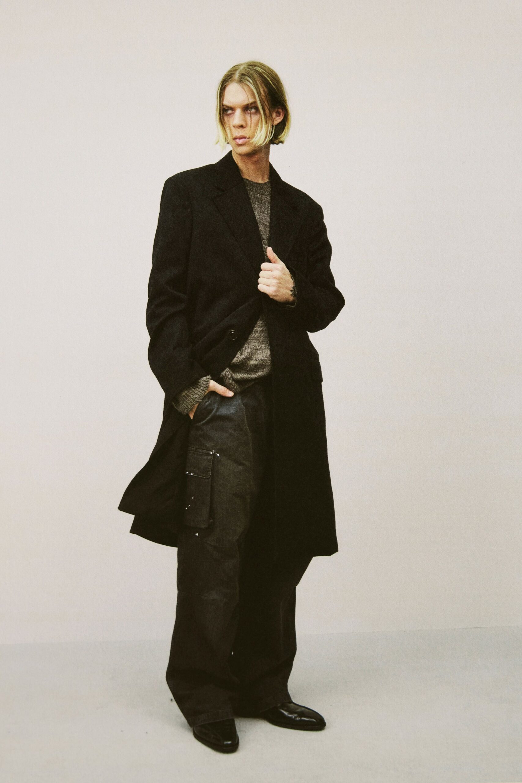 black wool coat gray sweater relaxed pants