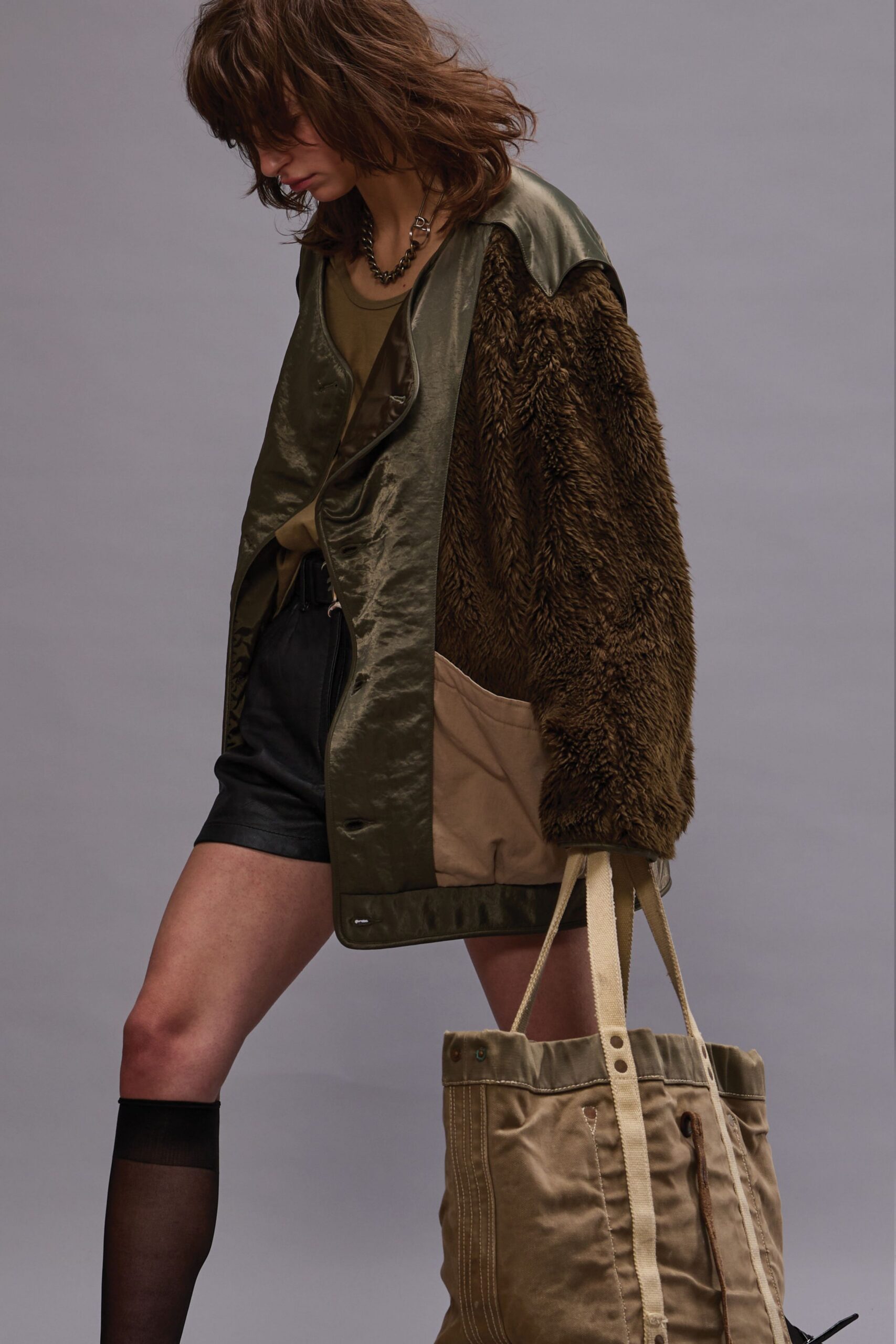 green faux-fur jacket with black shorts