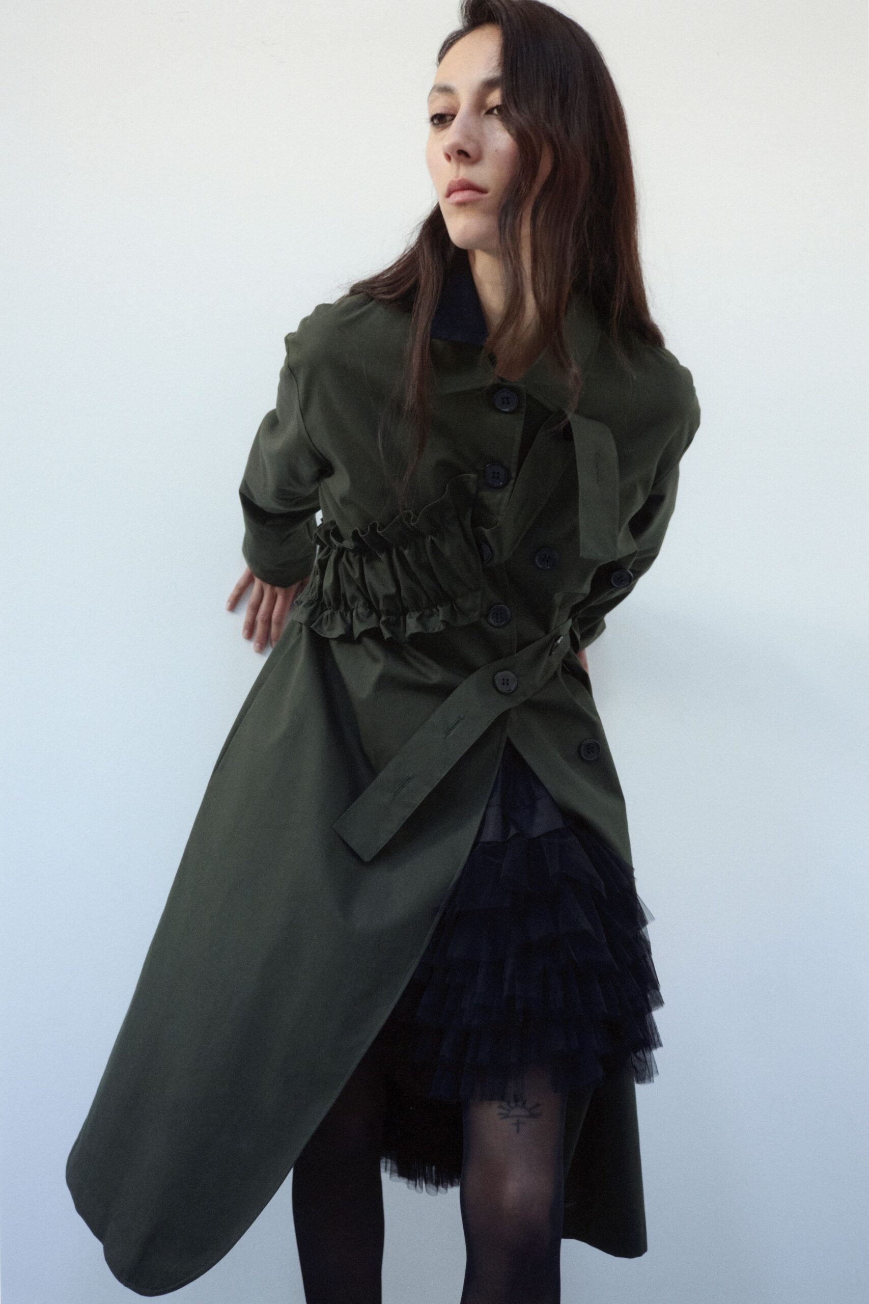 green belted coat and black tiered skirt
