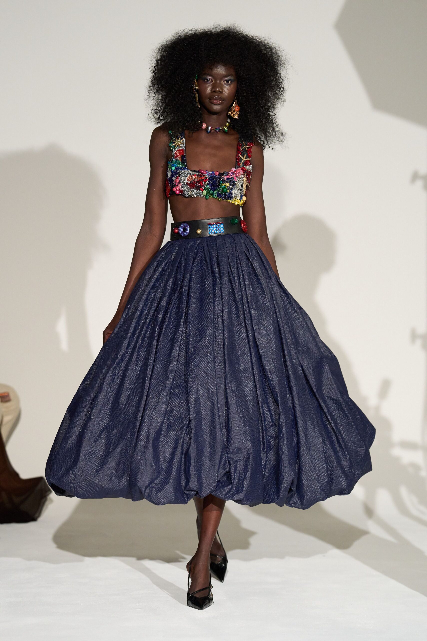 multi-colored embroidered top with blue pleated skirt