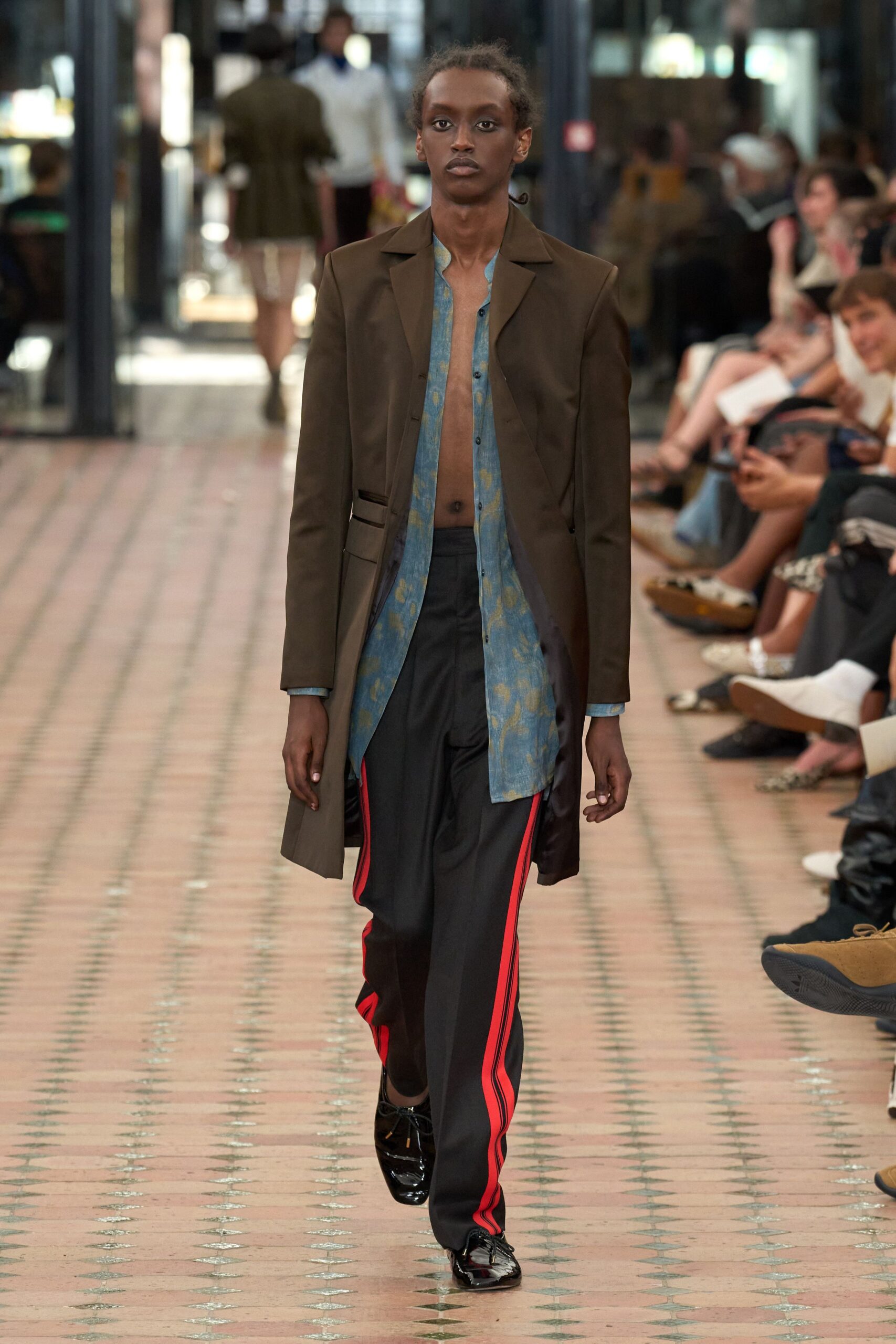 brown coat blue shirt black pants