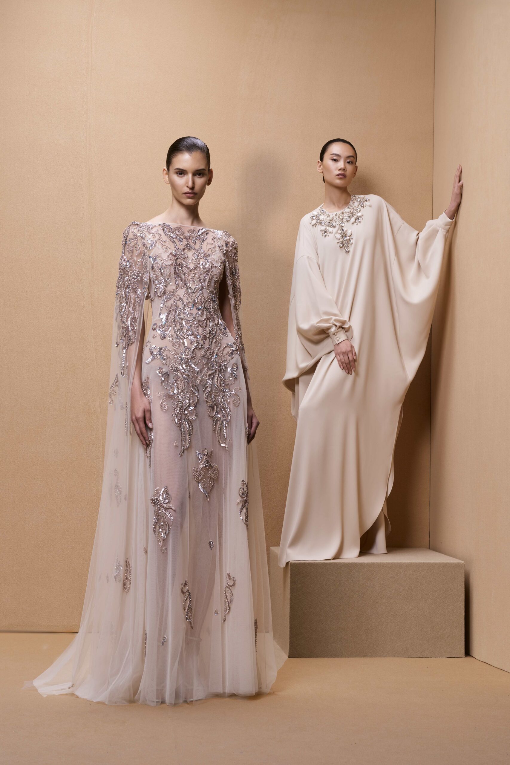 beige embellished gown and ivory draped dress