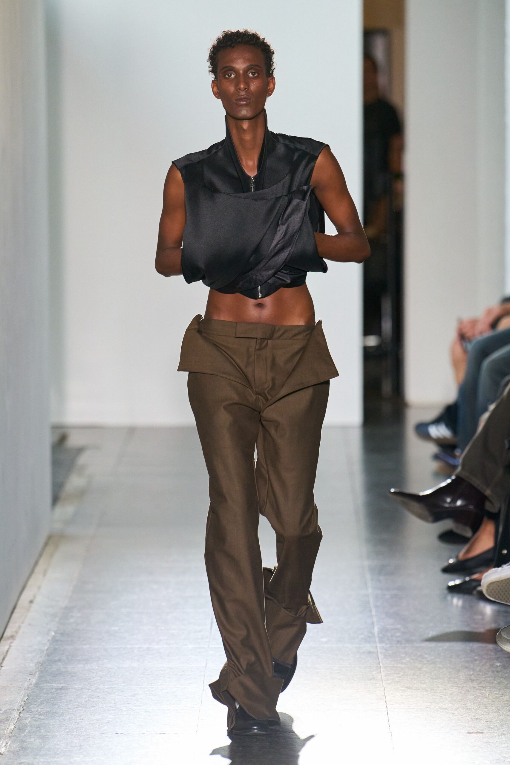 black silk sleeveless top and brown pants