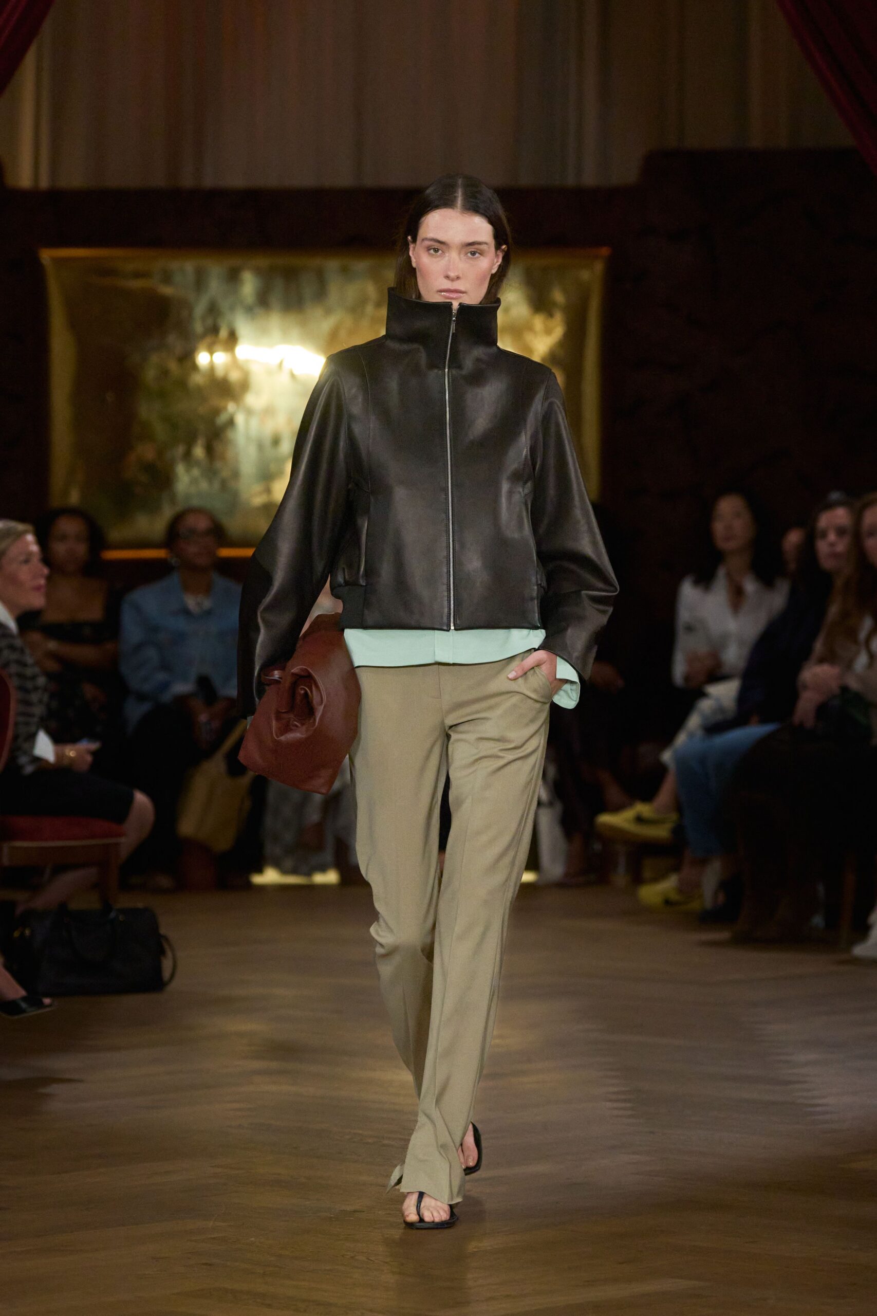 black leather jacket with beige pants