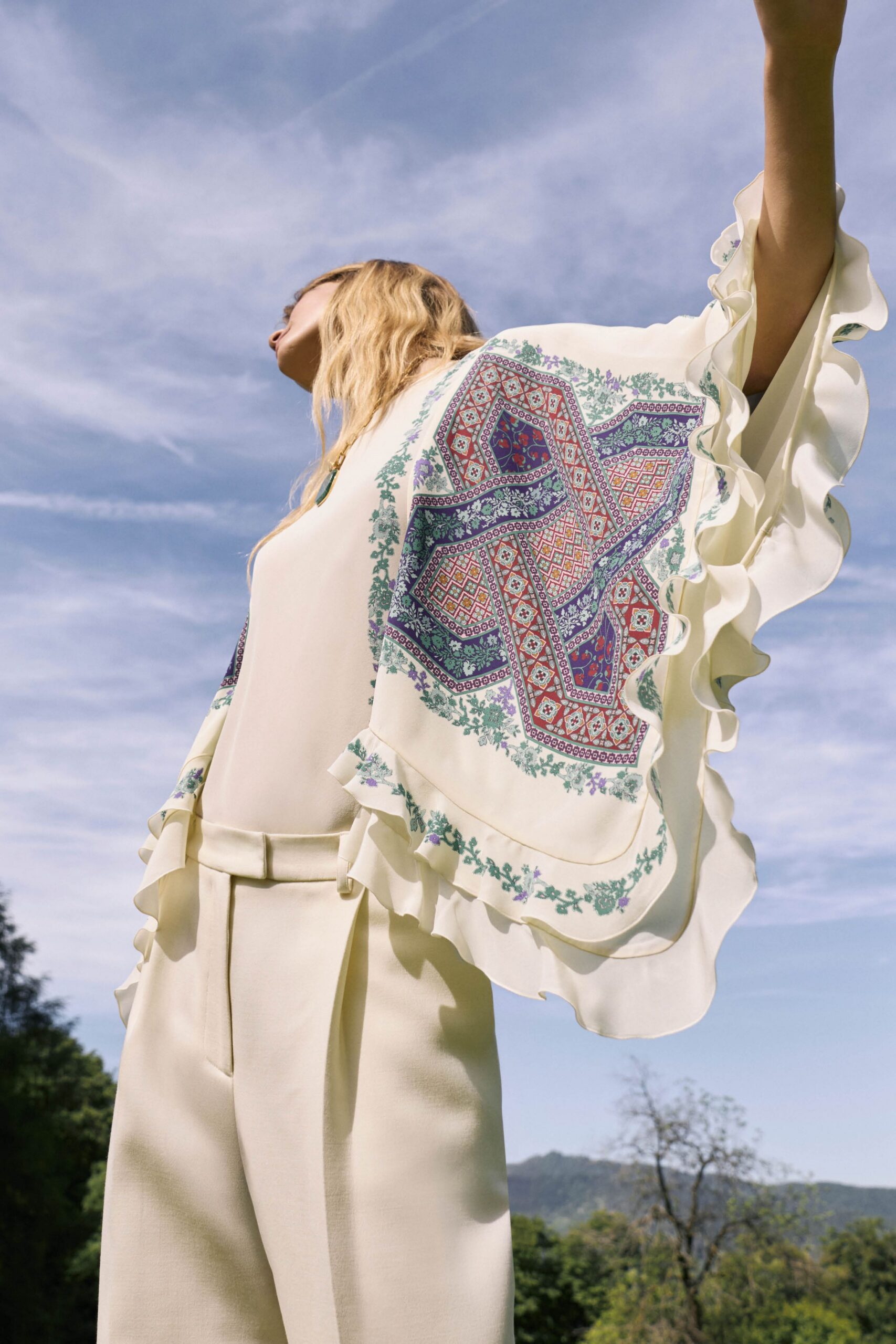 white silk ruffled top and beige tailored pants