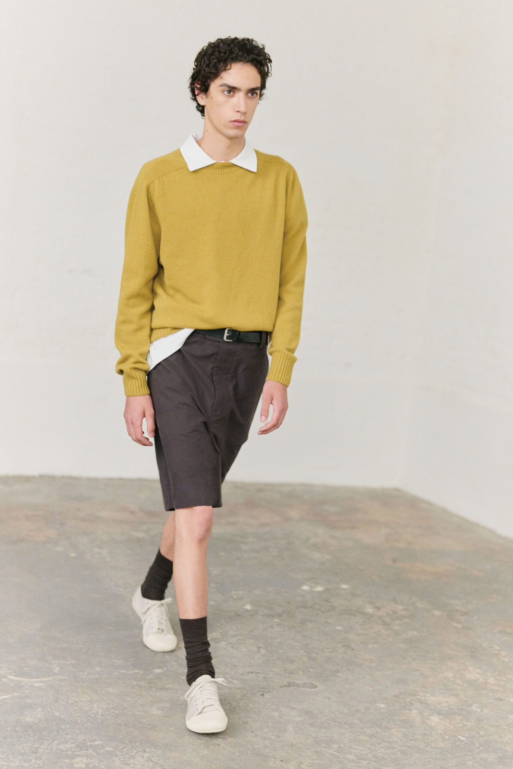 yellow relaxed sweater with black shorts