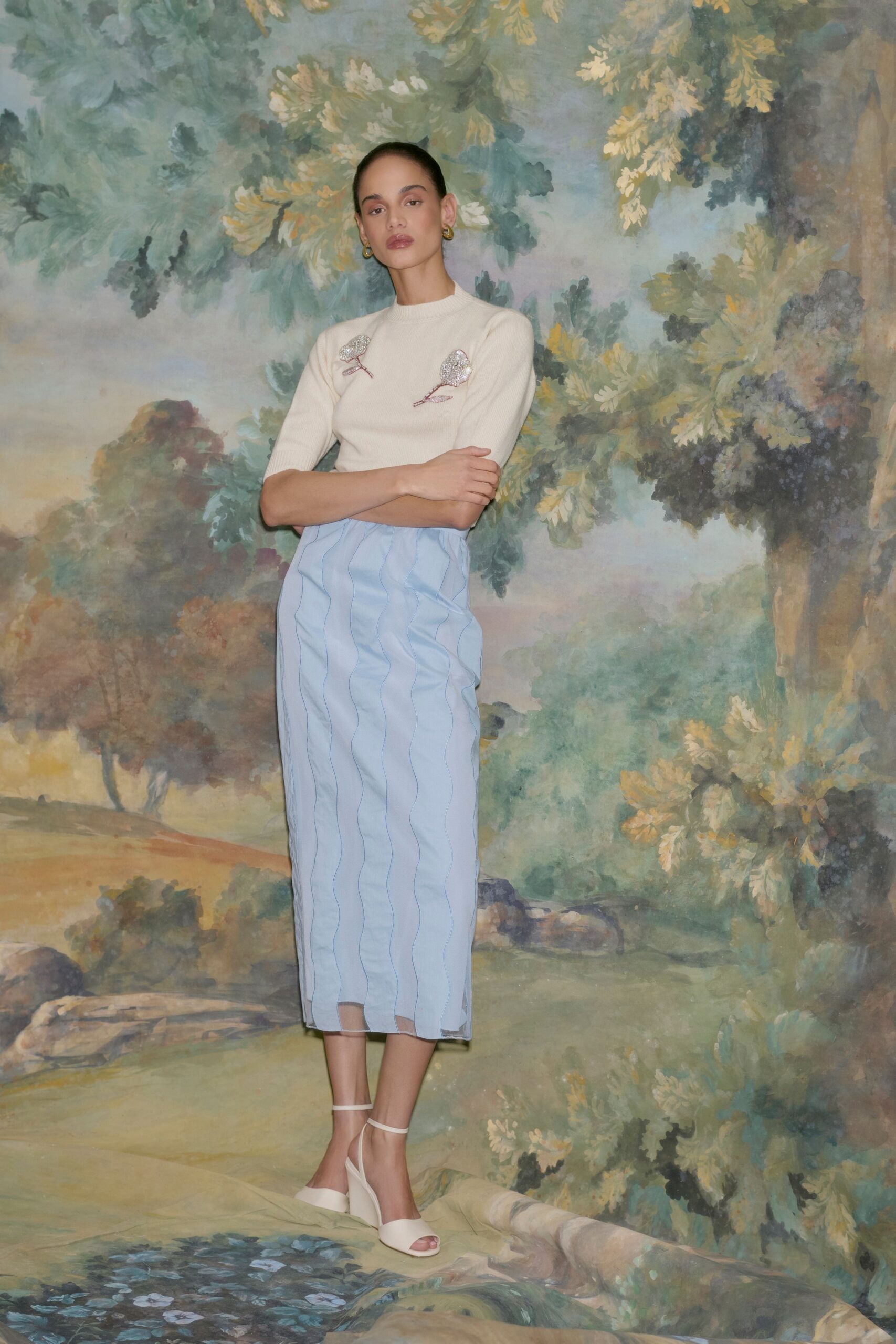 beige embroidered top with blue pleated skirt