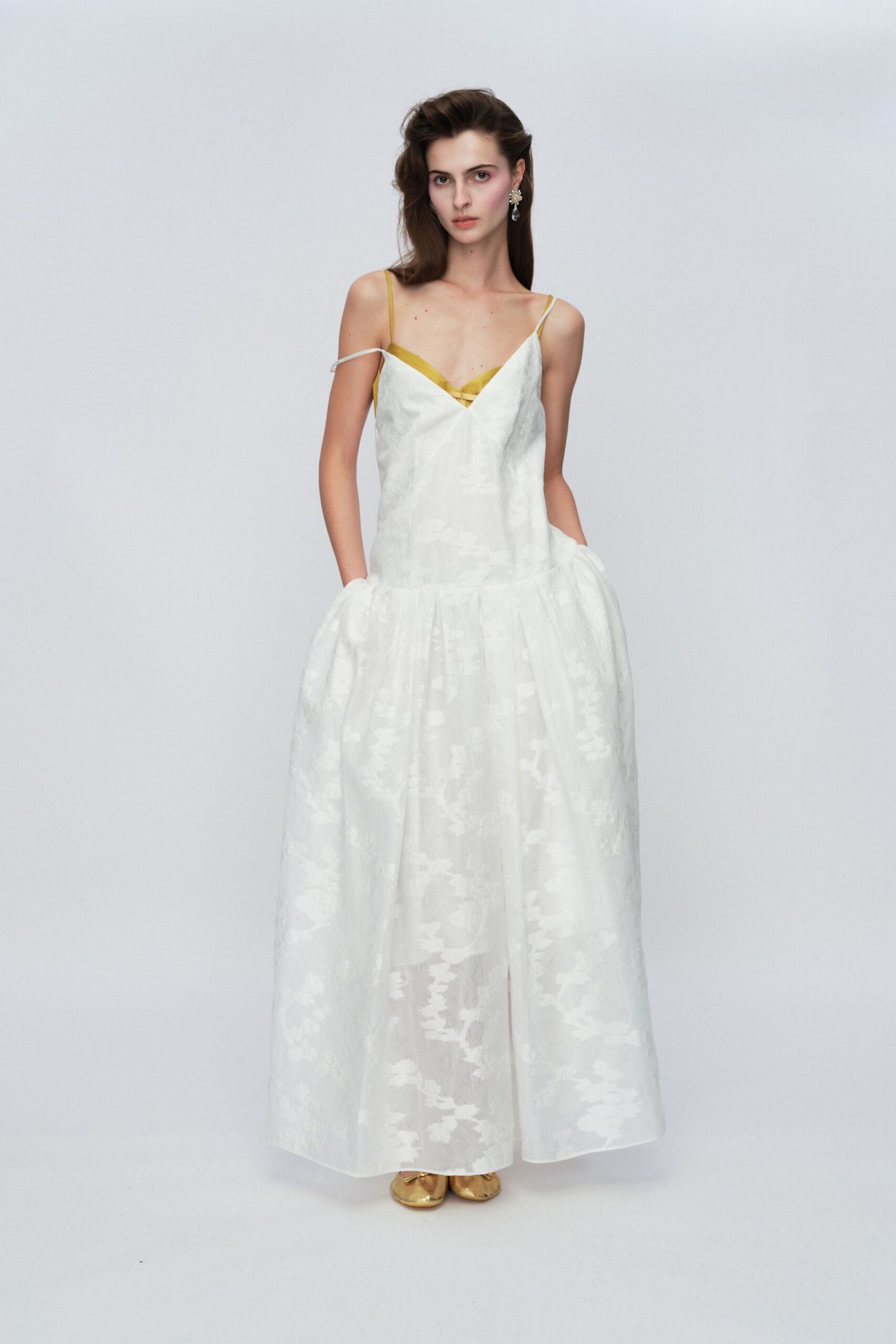 white silk sleeveless gown with gold shoes