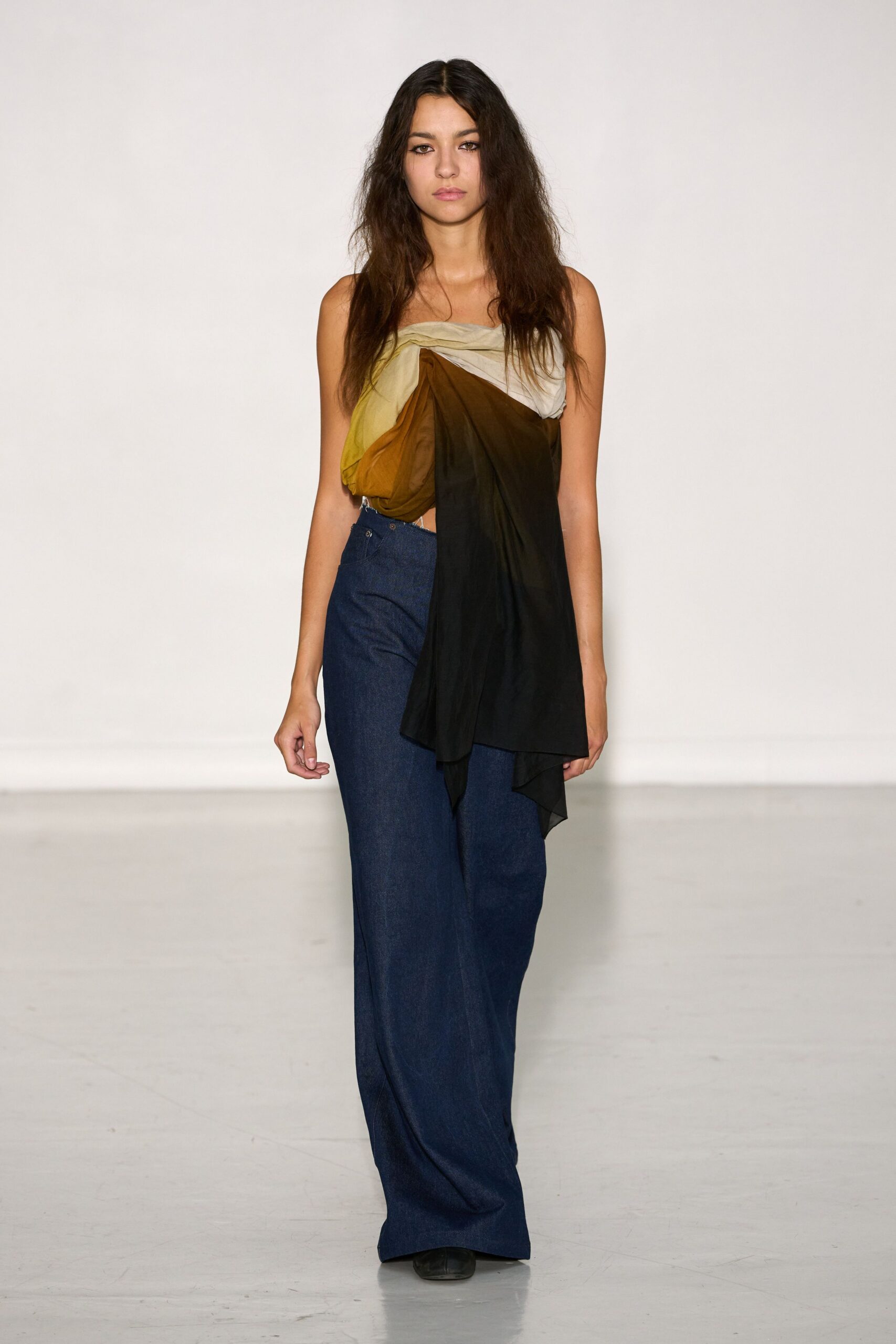 black and orange draped top with blue wide-leg pants