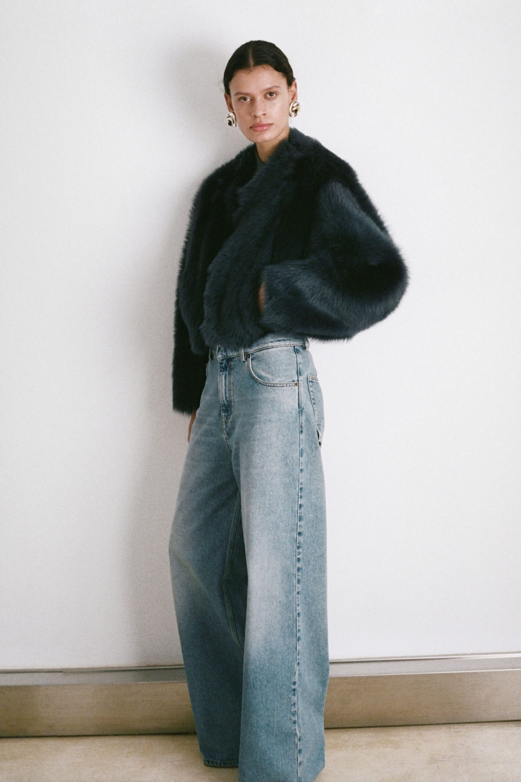 black faux-fur coat and blue jeans