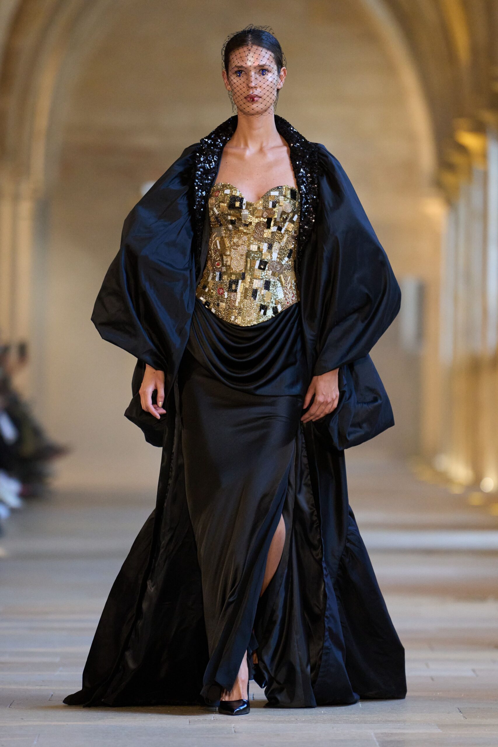 black and gold sequined gown with cape