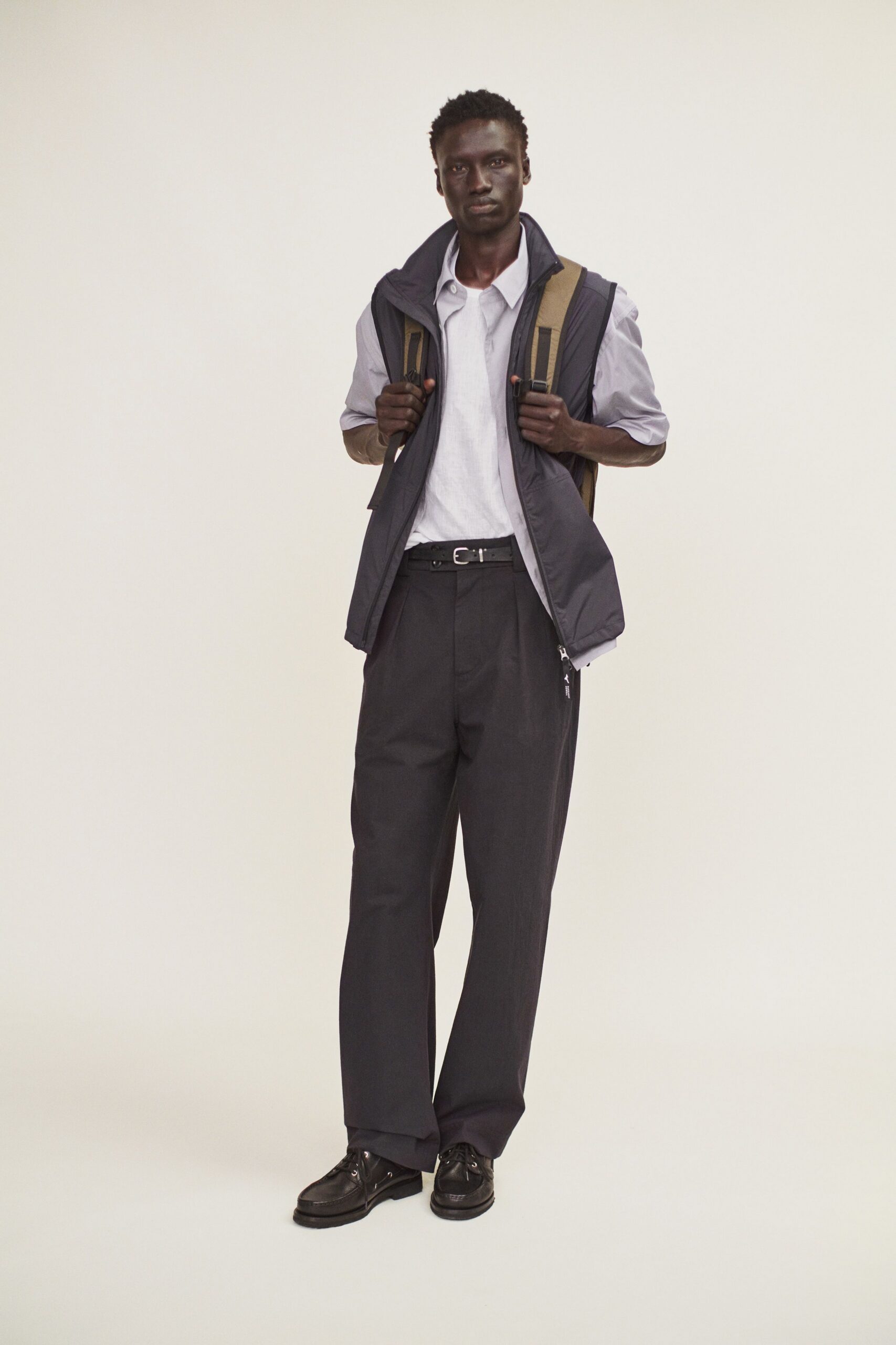 white shirt black vest gray pants