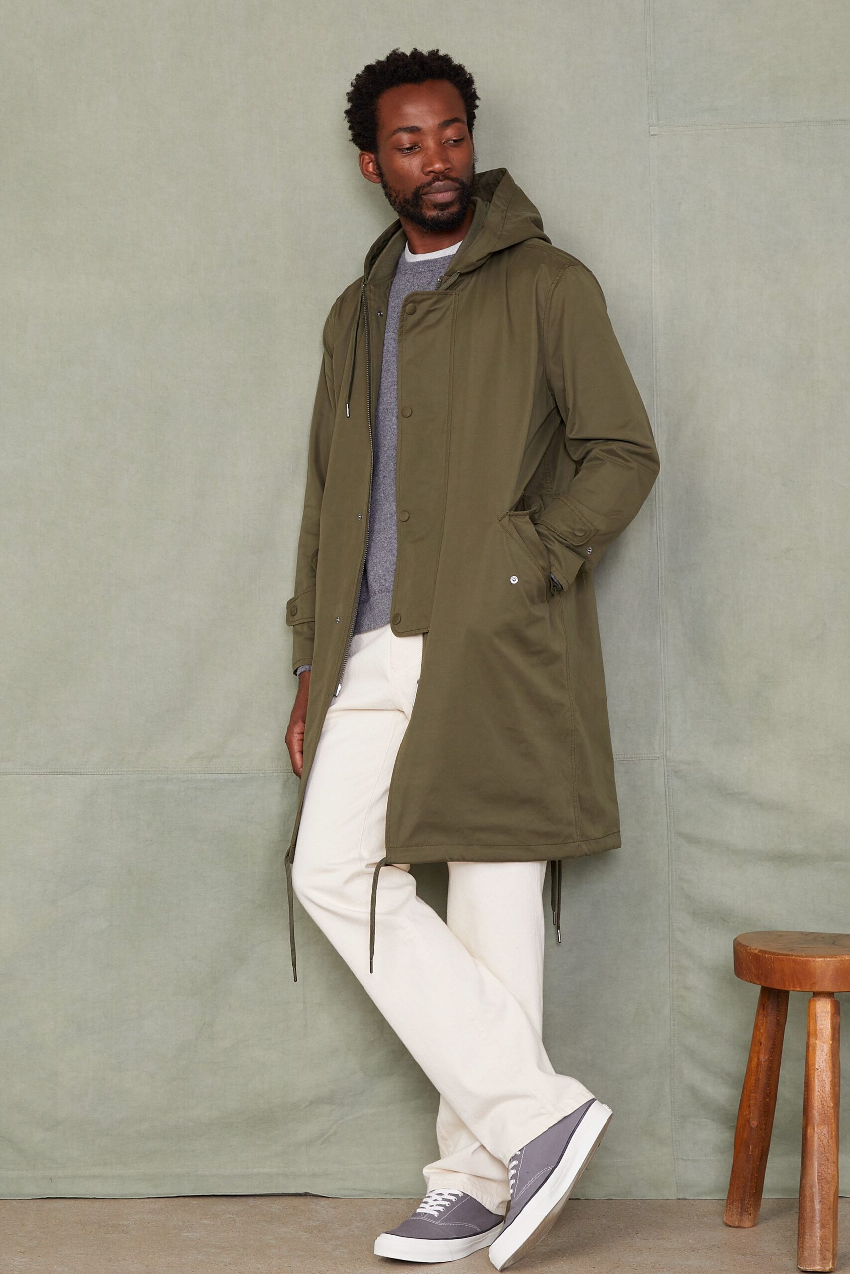 green parka gray sweater white pants