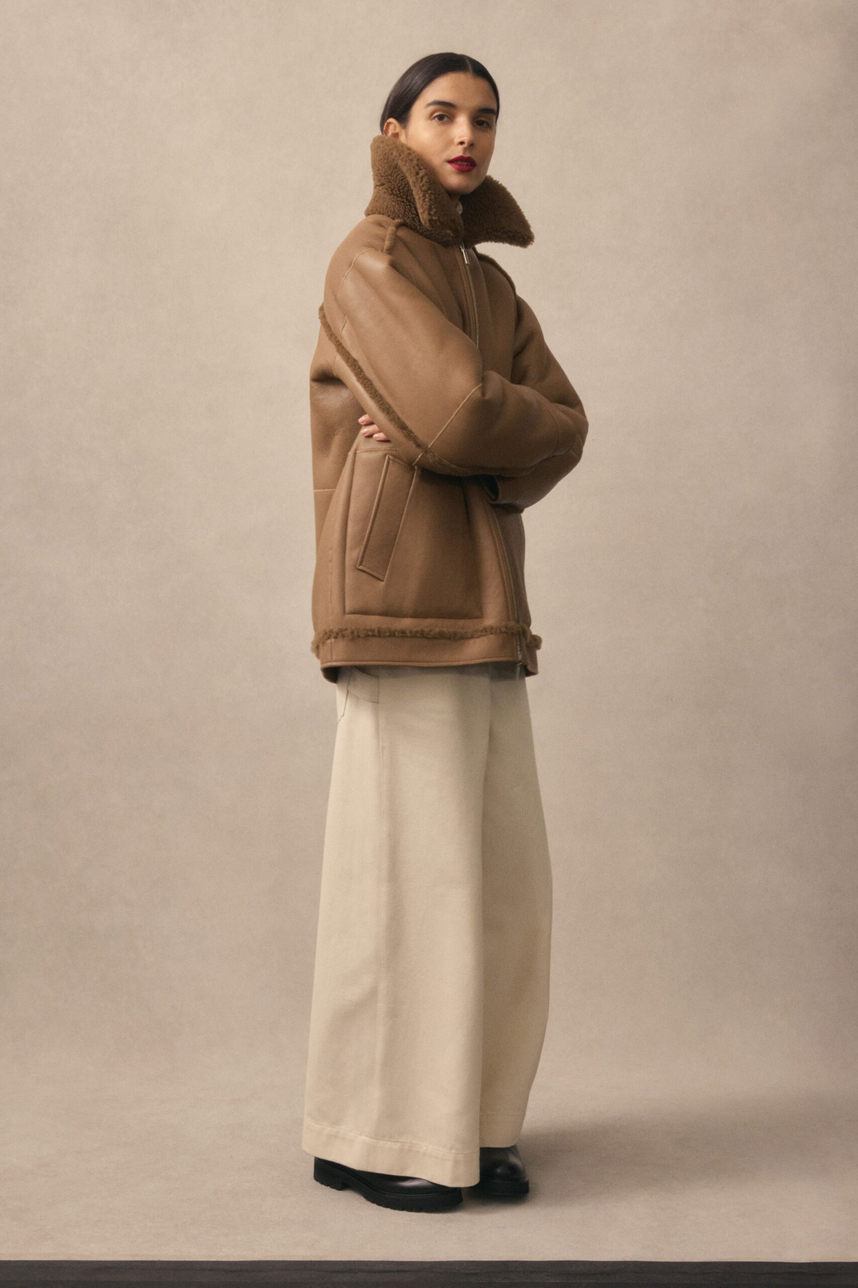 brown oversized leather jacket with beige pants