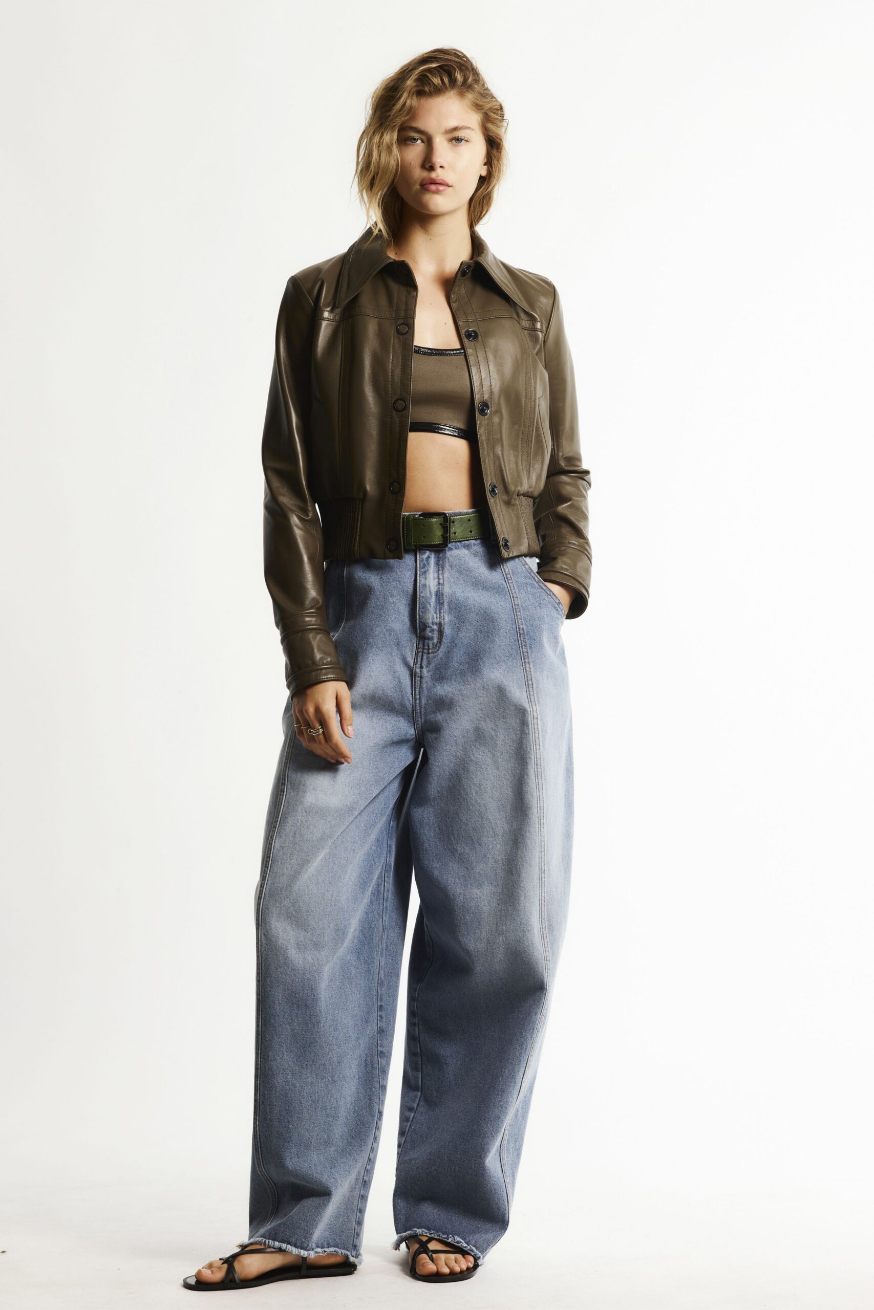 brown leather jacket black top blue pants